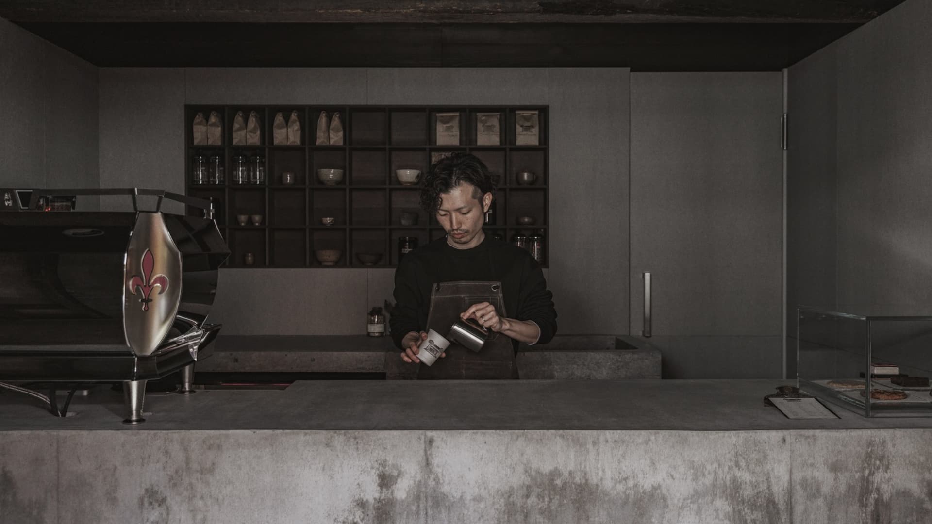 A coffee shop counter made of concrete and wood