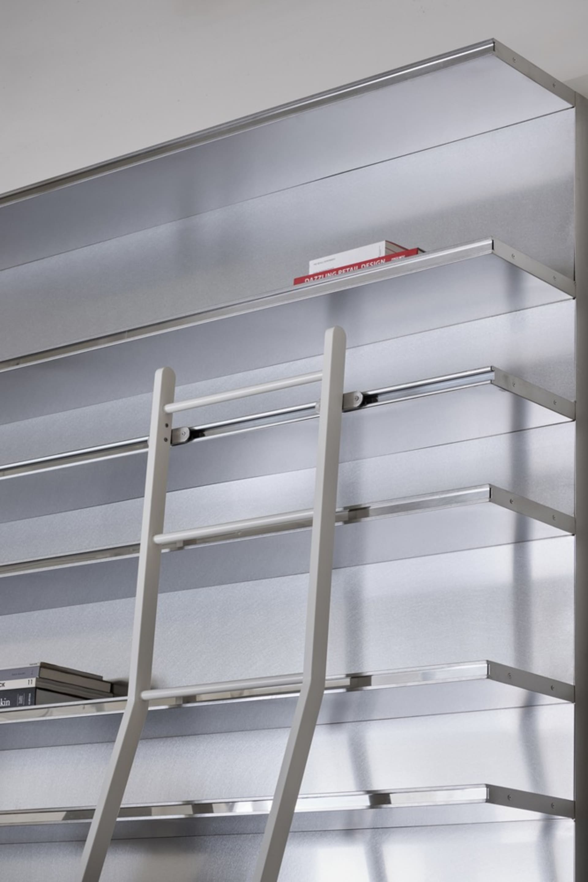 Metallic shelving system with a ladder in an industrial library setting.