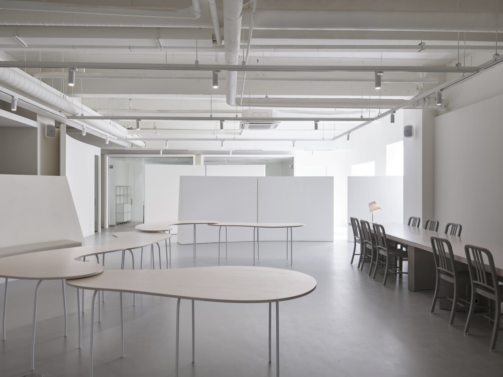 An empty, minimalist office space with white walls and furniture.