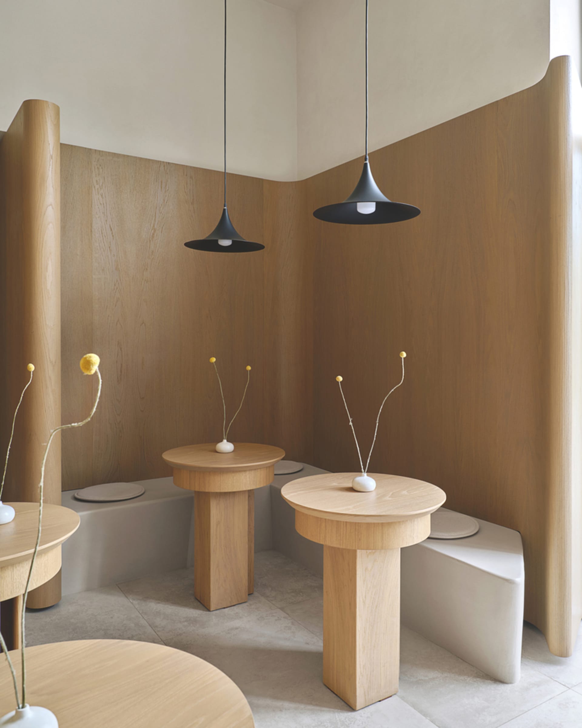 A contemporary Scandinavian-style cafe interior with wooden tables and pendant lights