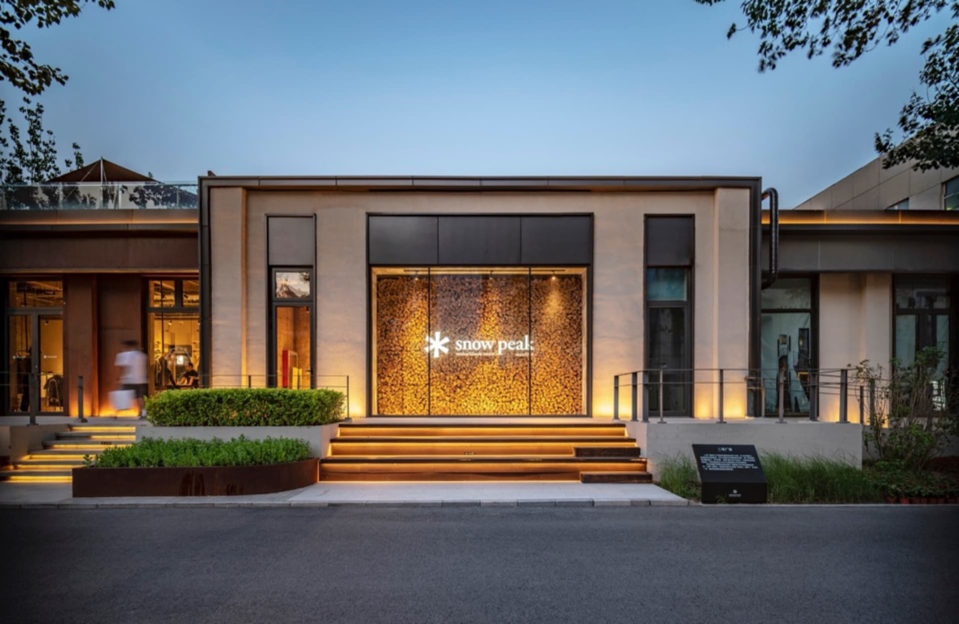 A modern retail storefront featuring glass, metal, and stone materials.