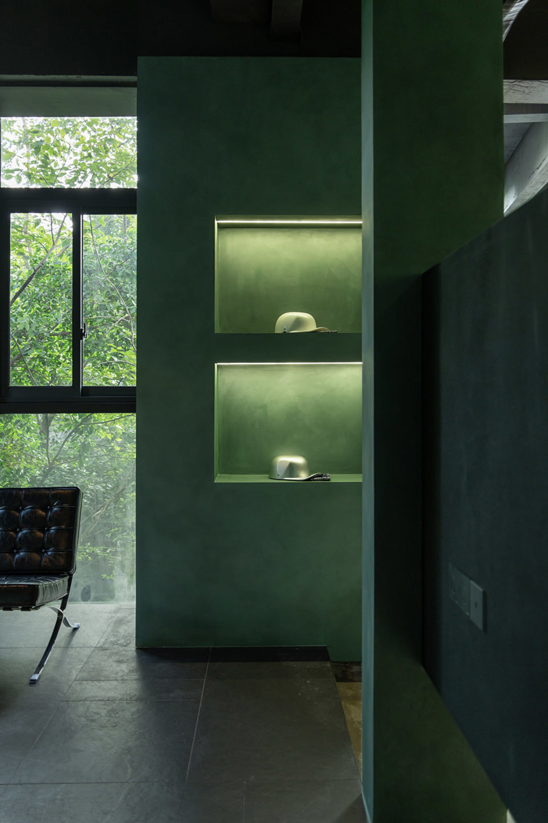 Modern minimalist interior with green plaster shelves and concrete elements