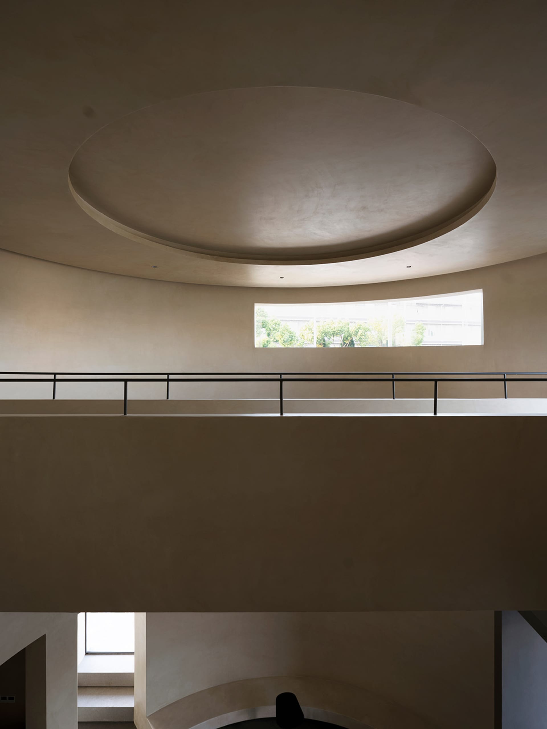 An interior space with a modern design featuring concrete walls and a curved ceiling.