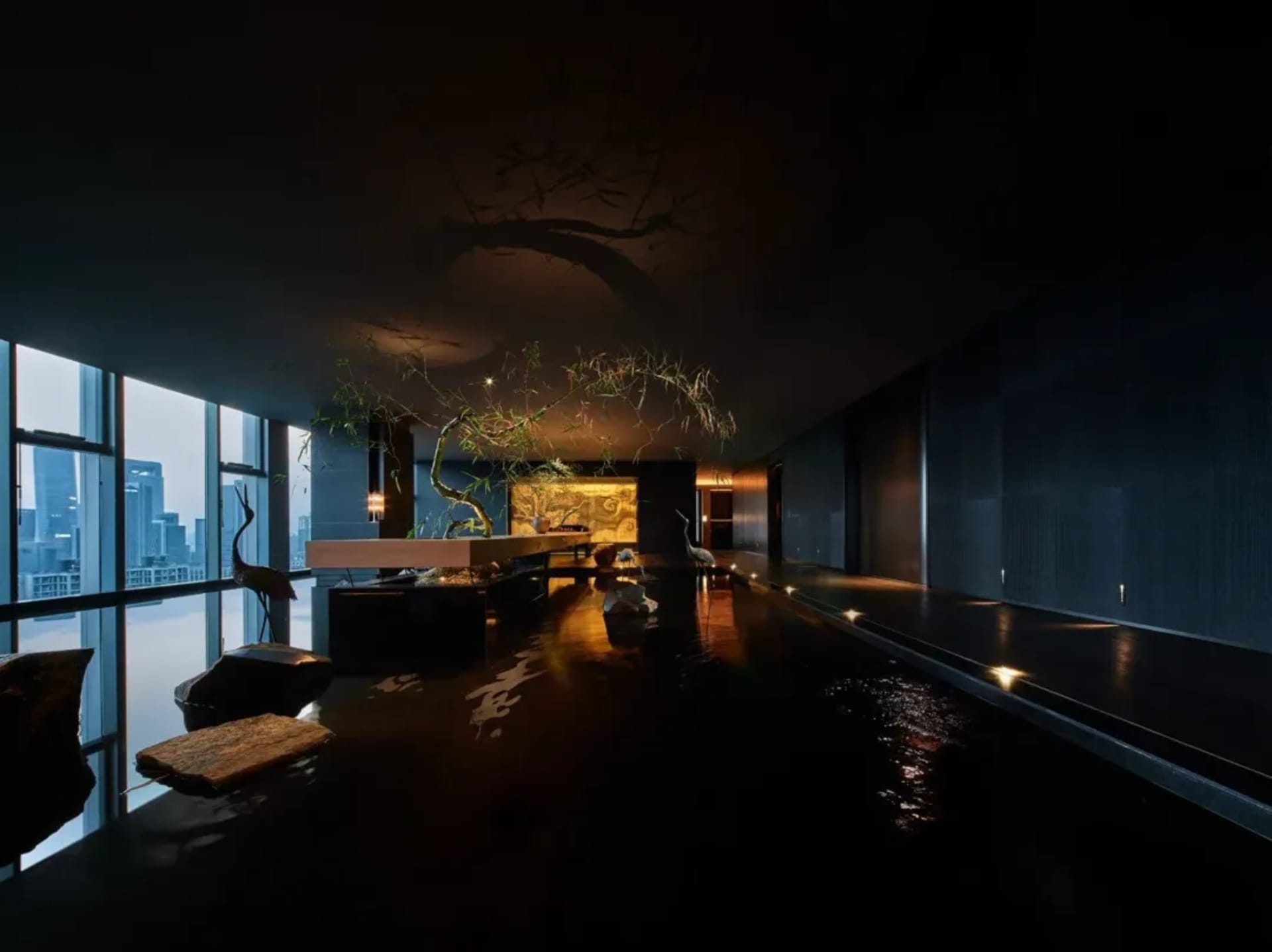 Modern interior featuring an atrium with a glass wall, water feature, and wooden accents.