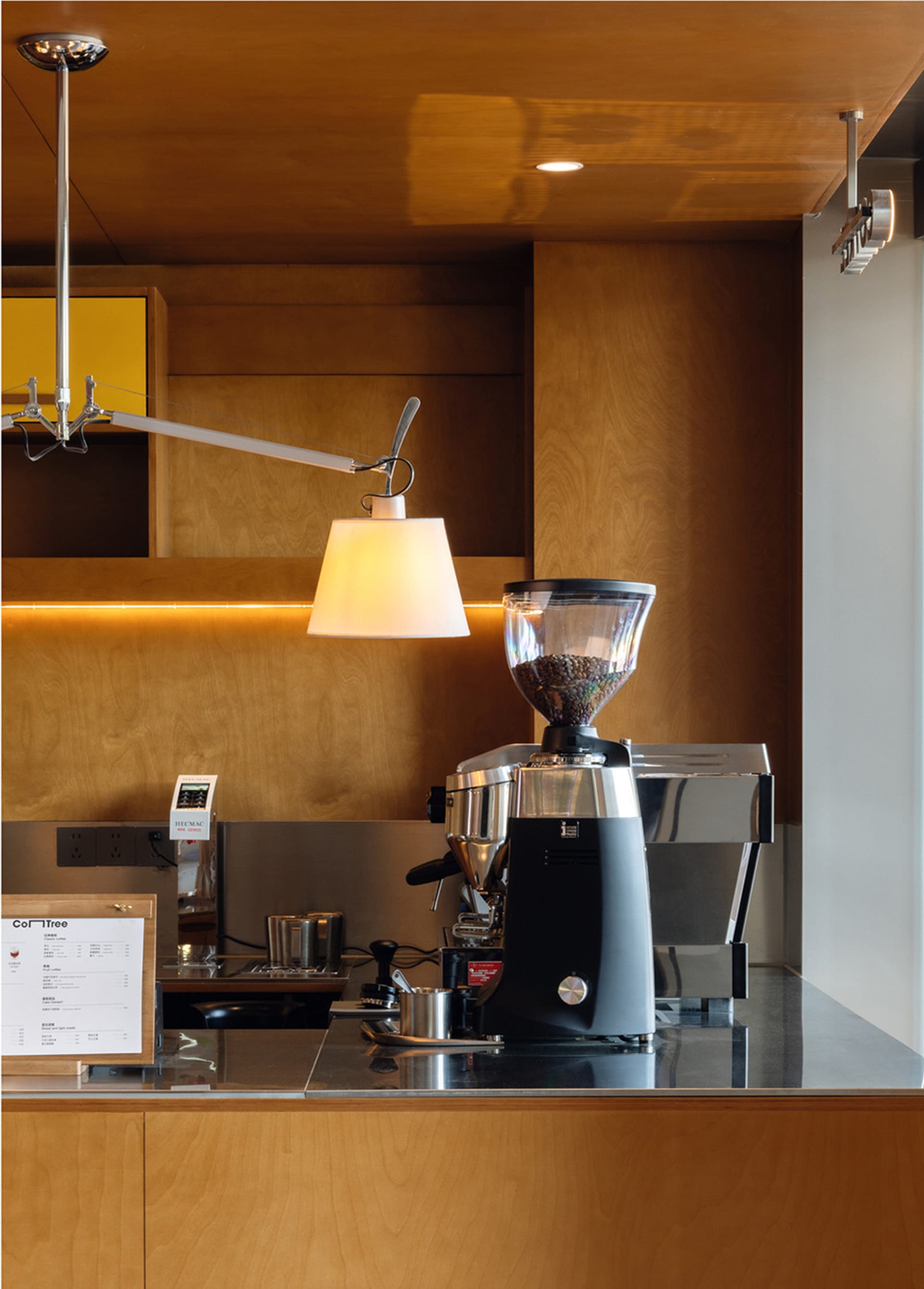 Modern coffee shop with a coffee roaster mounted on a wooden wall.