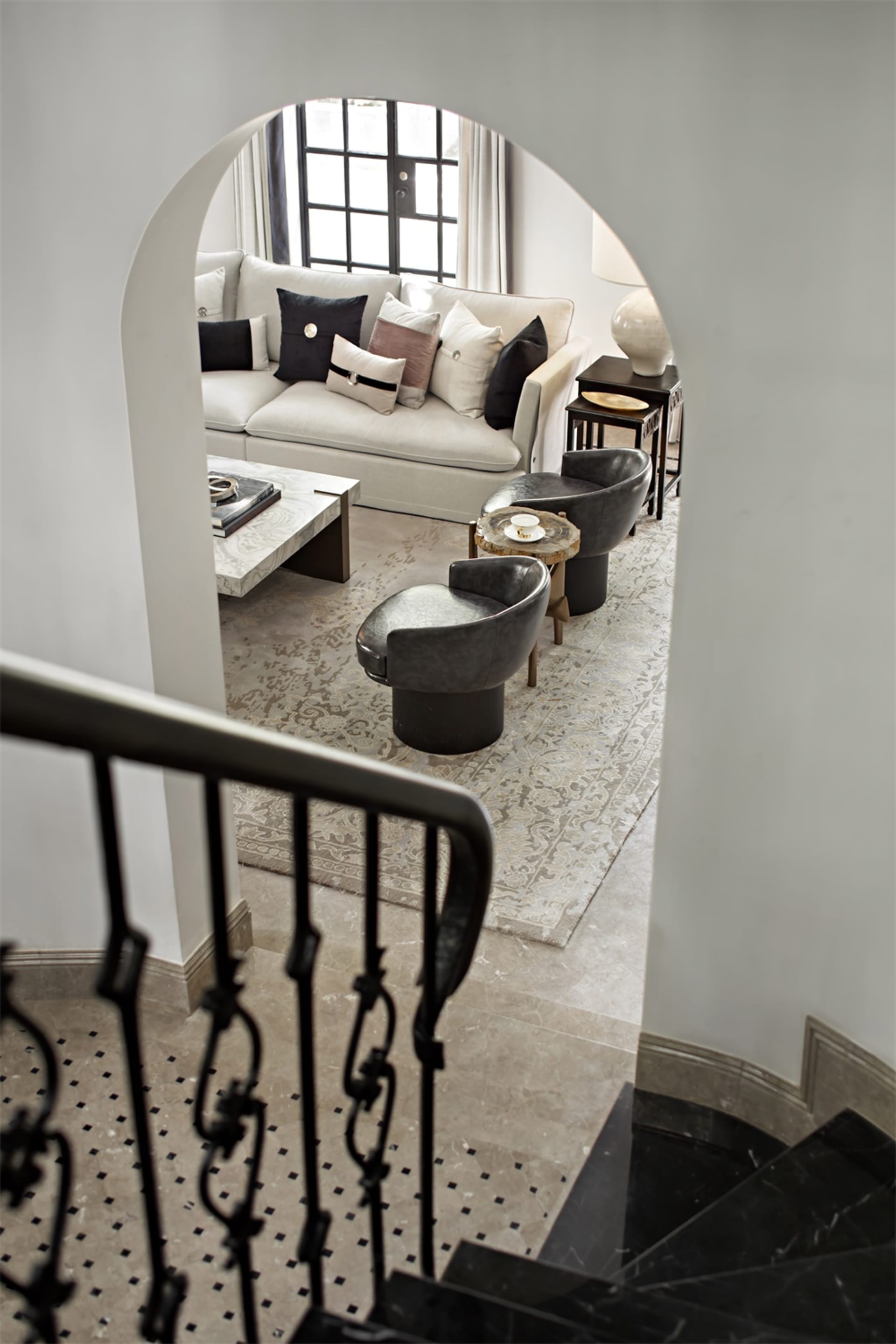 簡約客廳擁有大理石地板與混凝土壁爐，搭配現代家具及大型窗戶。