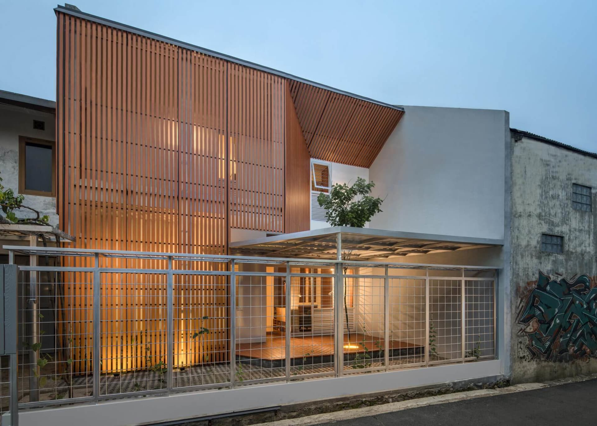 Modern house with wooden plank facade at dusk.