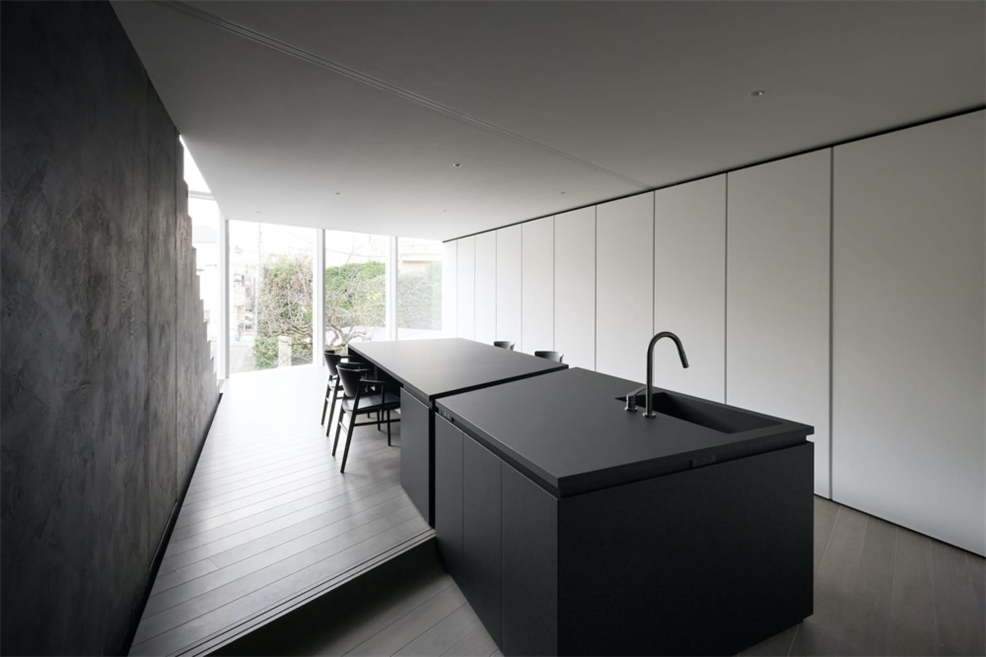 Modern minimalist interior with black marble countertops and concrete walls.