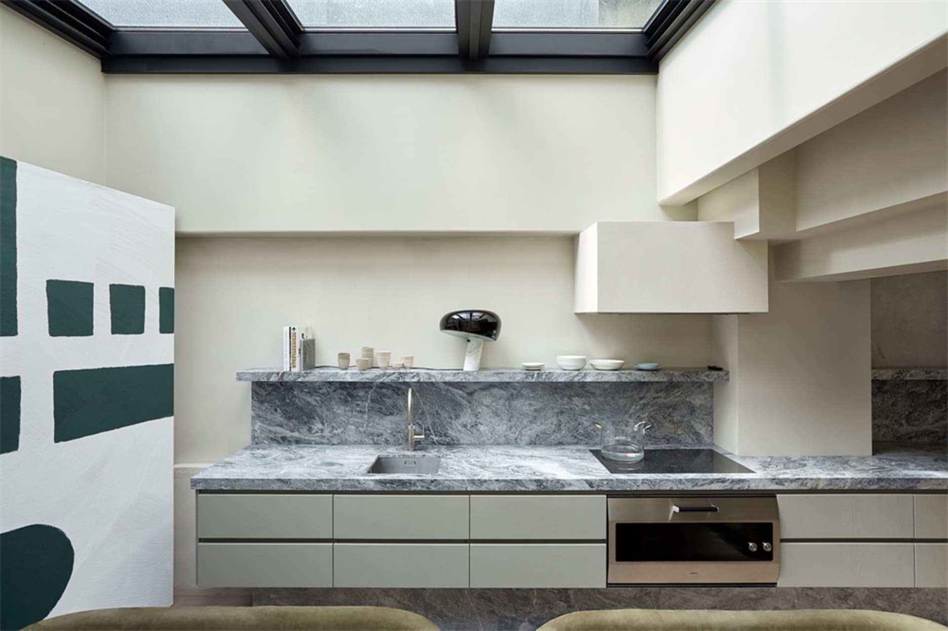 Modern kitchen with marble countertops and grey stone backsplash