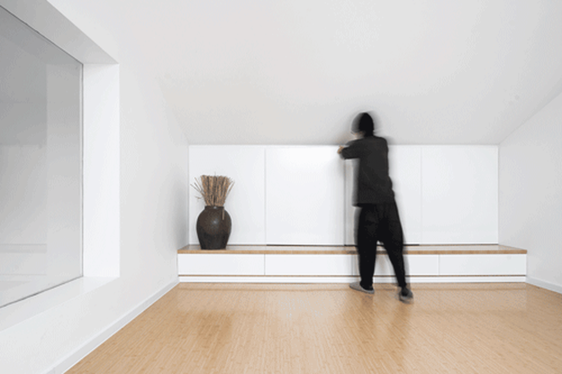 A modern living space with white cabinets and bamboo floors
