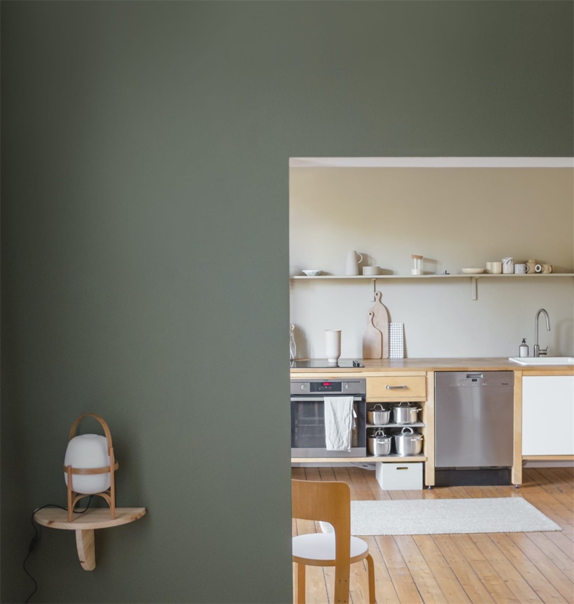 Modern minimalist kitchen with wooden cabinets and open shelving.
