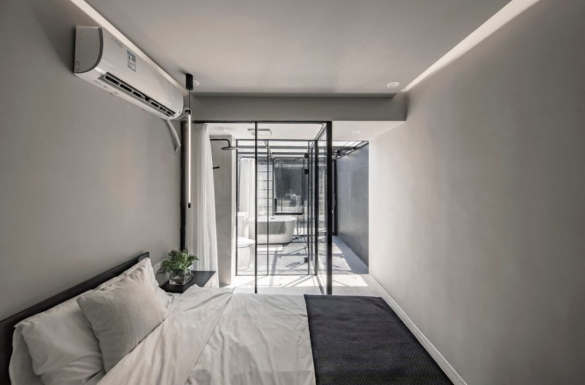 Modern bedroom featuring concrete walls and glass elements