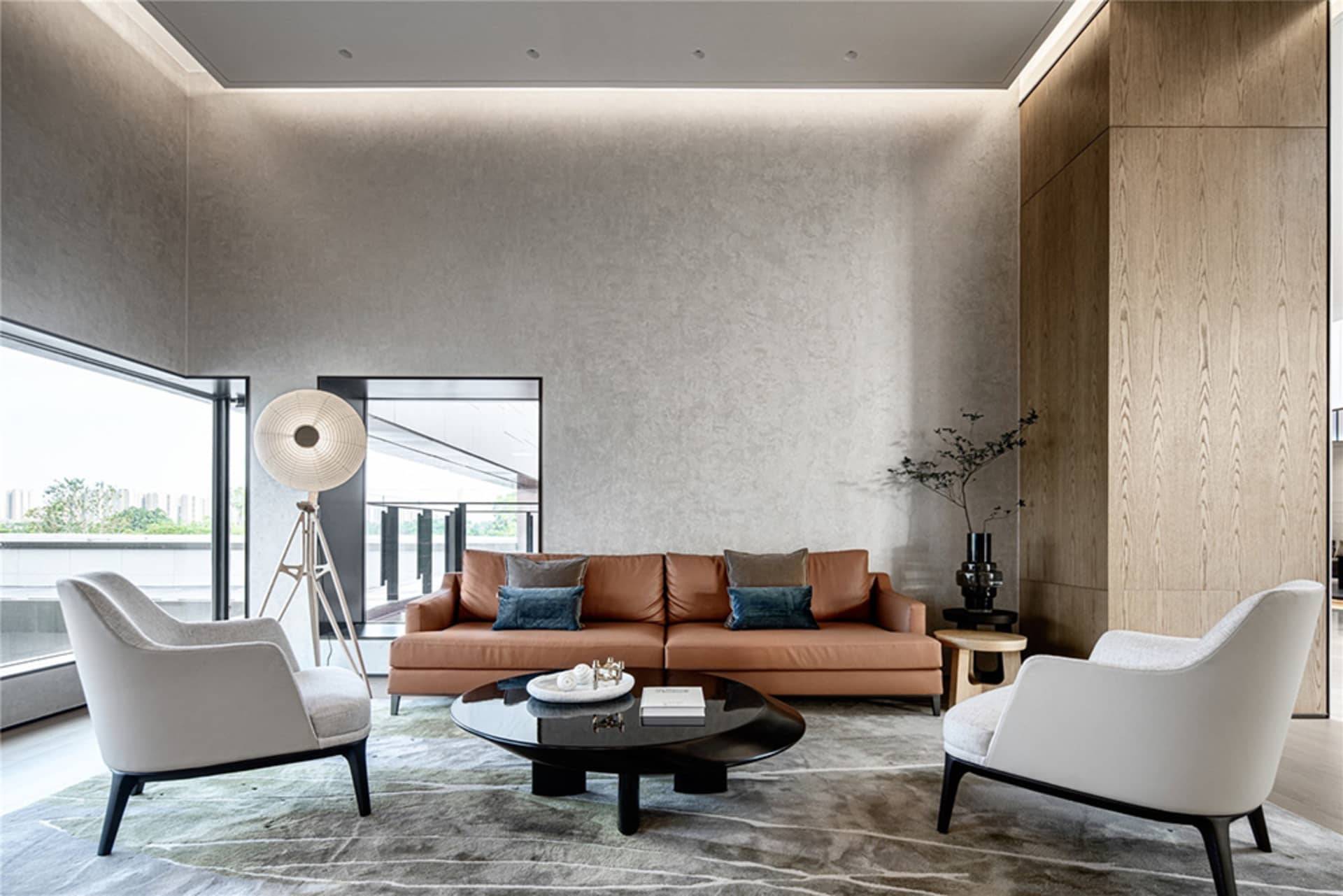 Modern living room with brown sofa, white chairs, and a black coffee table, featuring a large window with a view of the outdo