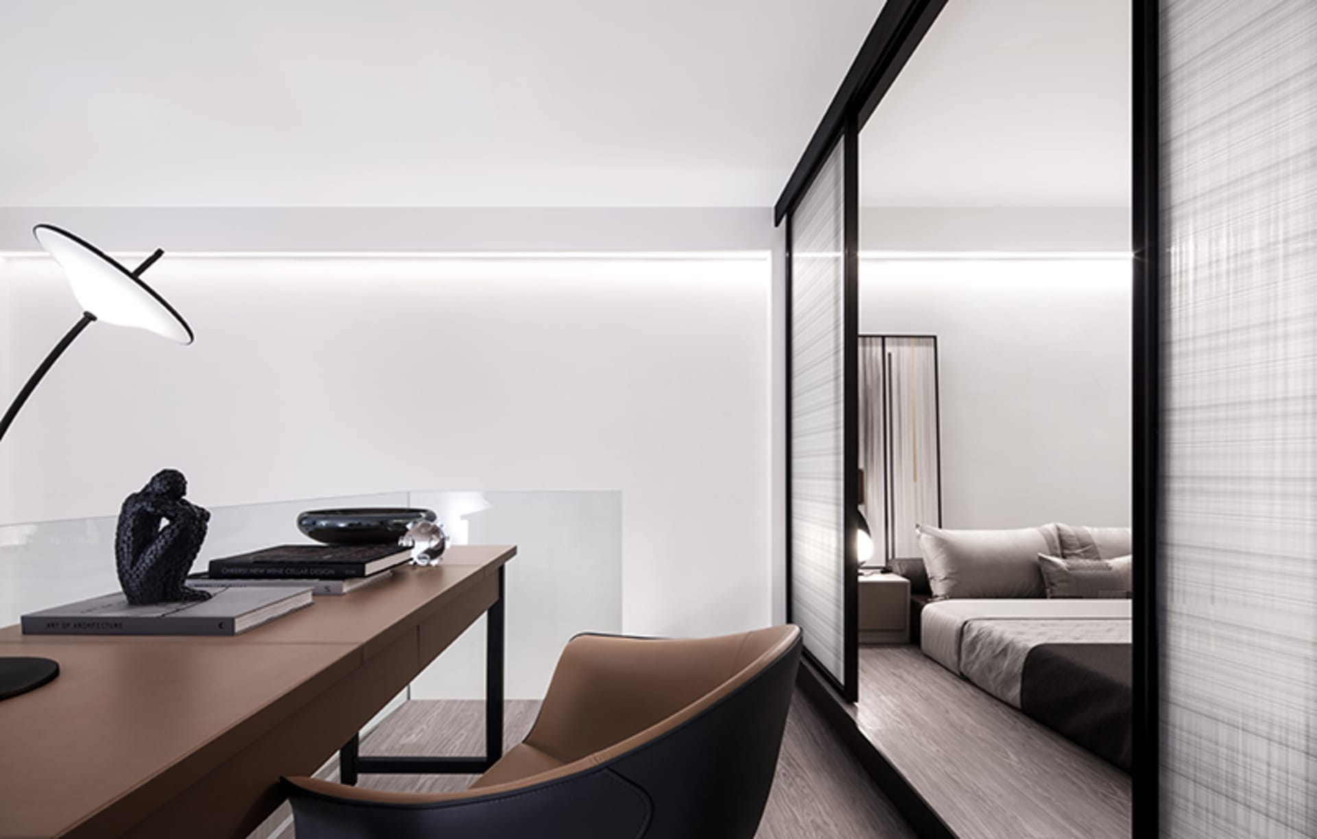 A modern minimalist bedroom featuring transparent glass walls and a sleek desk.