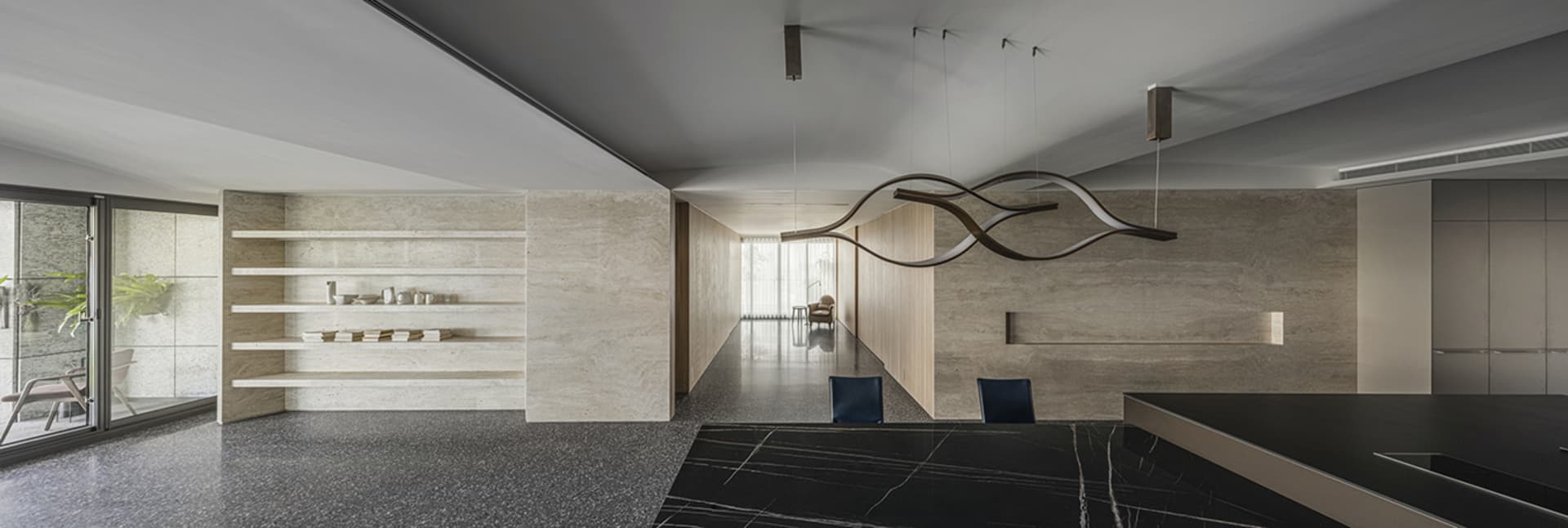 Modern minimalist living area with concrete walls and marble countertops.