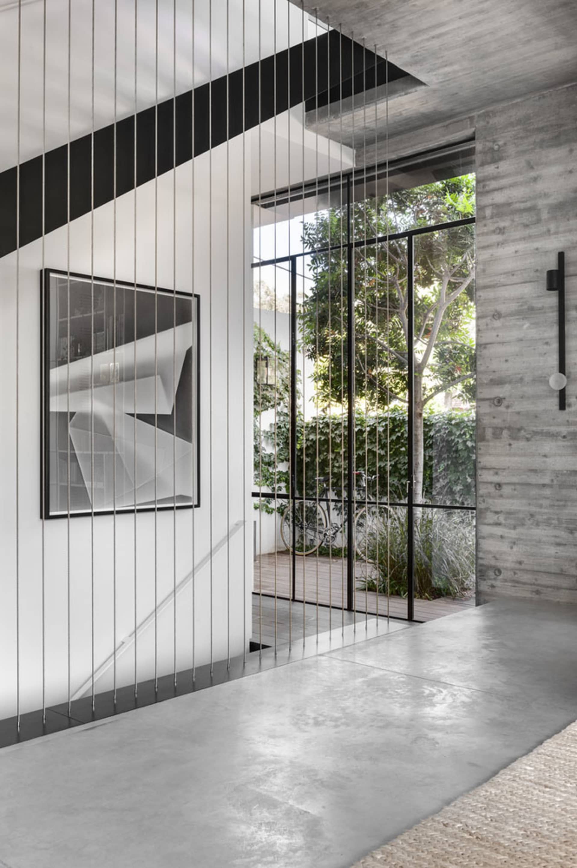 Modern, industrial-style interior with concrete walls and large window.
