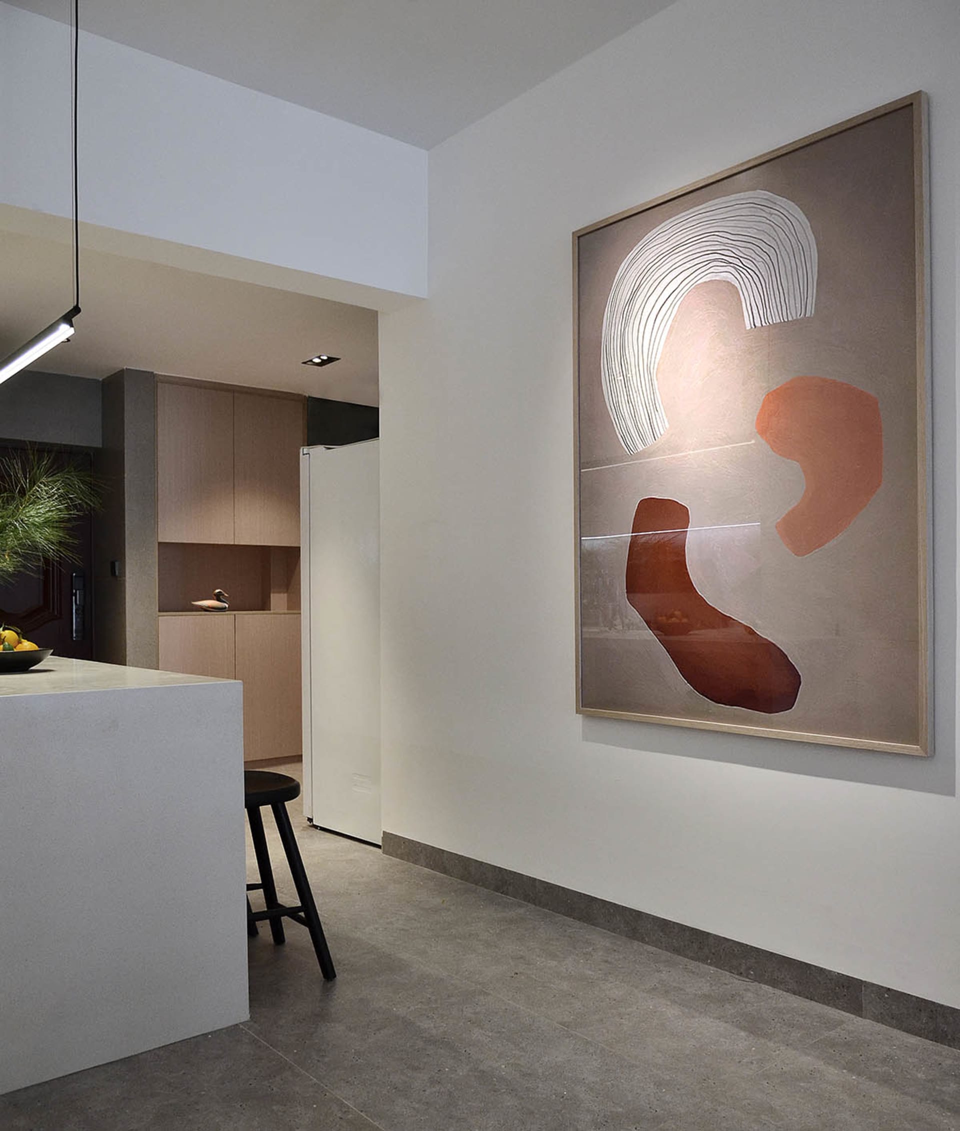 A modern minimalist kitchen with concrete finishes and abstract art.