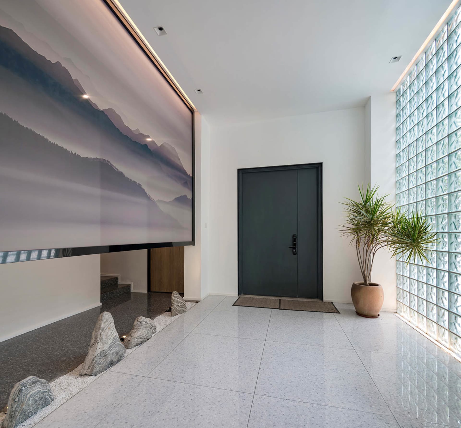 A minimalist entryway with glass walls, baby blue paneled ceiling, concrete floor tile, and porcelain surroundings.