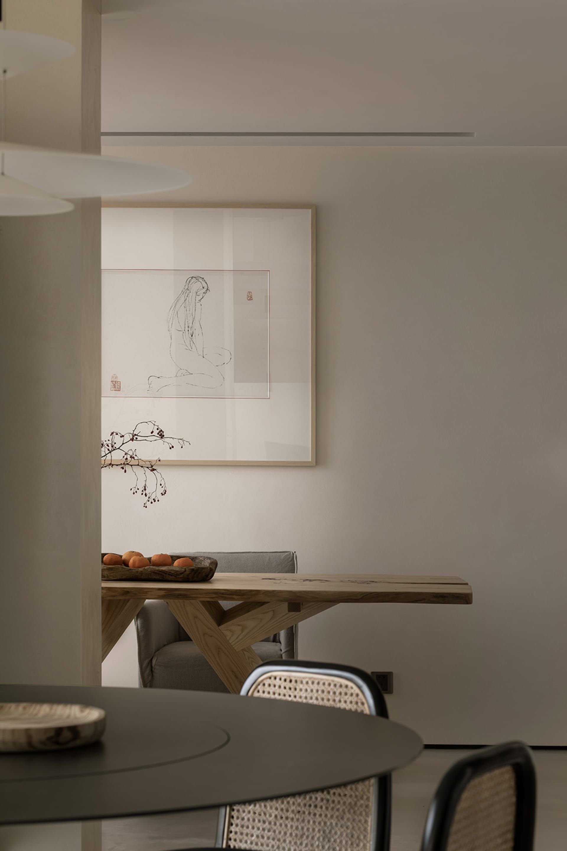 現代餐廳內擺放一張原木邊緣的黑色圓形餐桌,搭配編織餐椅。