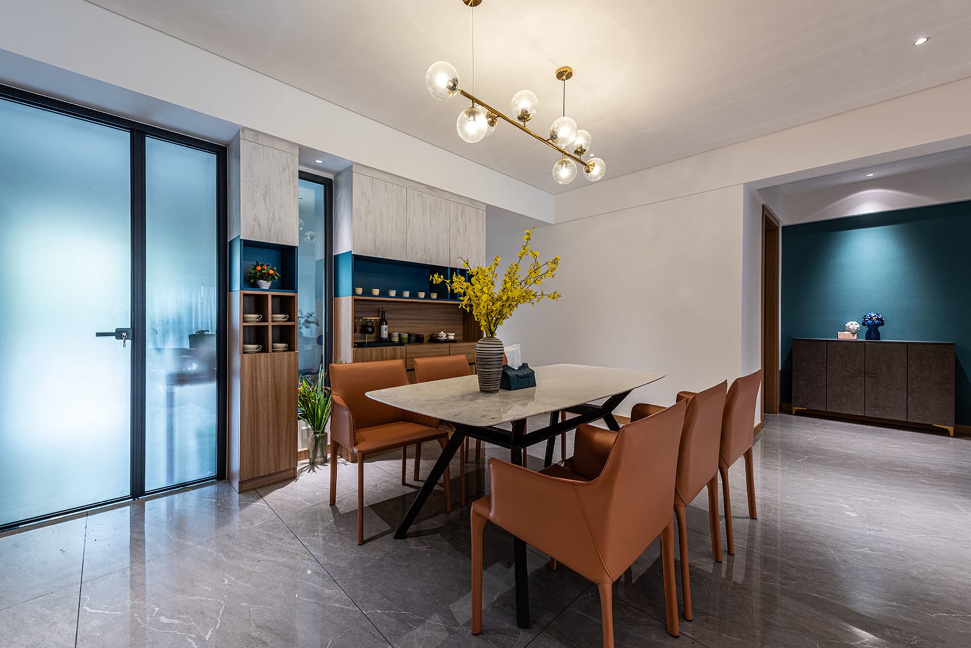 Modern dining room featuring a marble table and brown leather chairs.