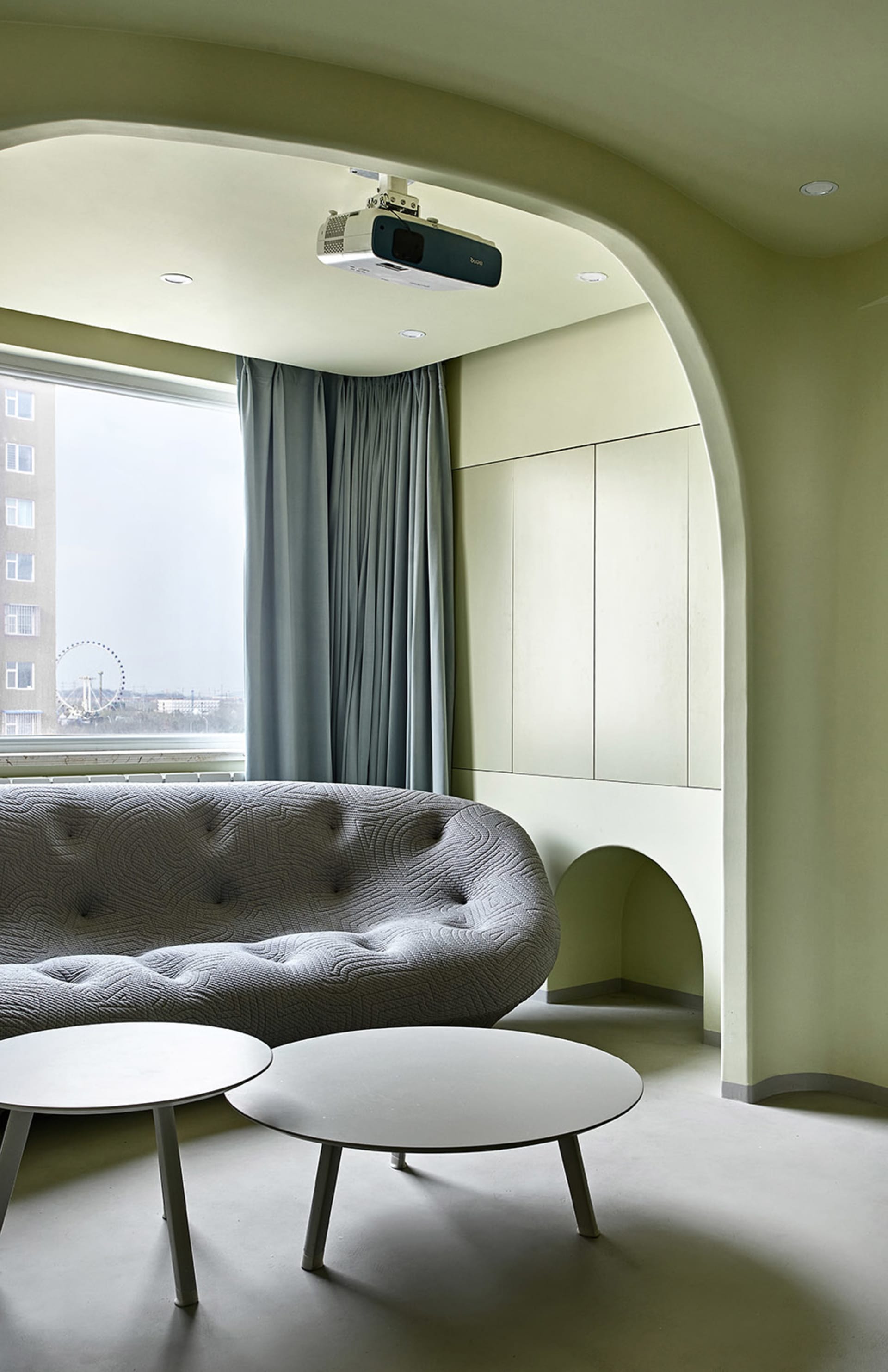 A minimalist living room with a concrete sofa and tables.