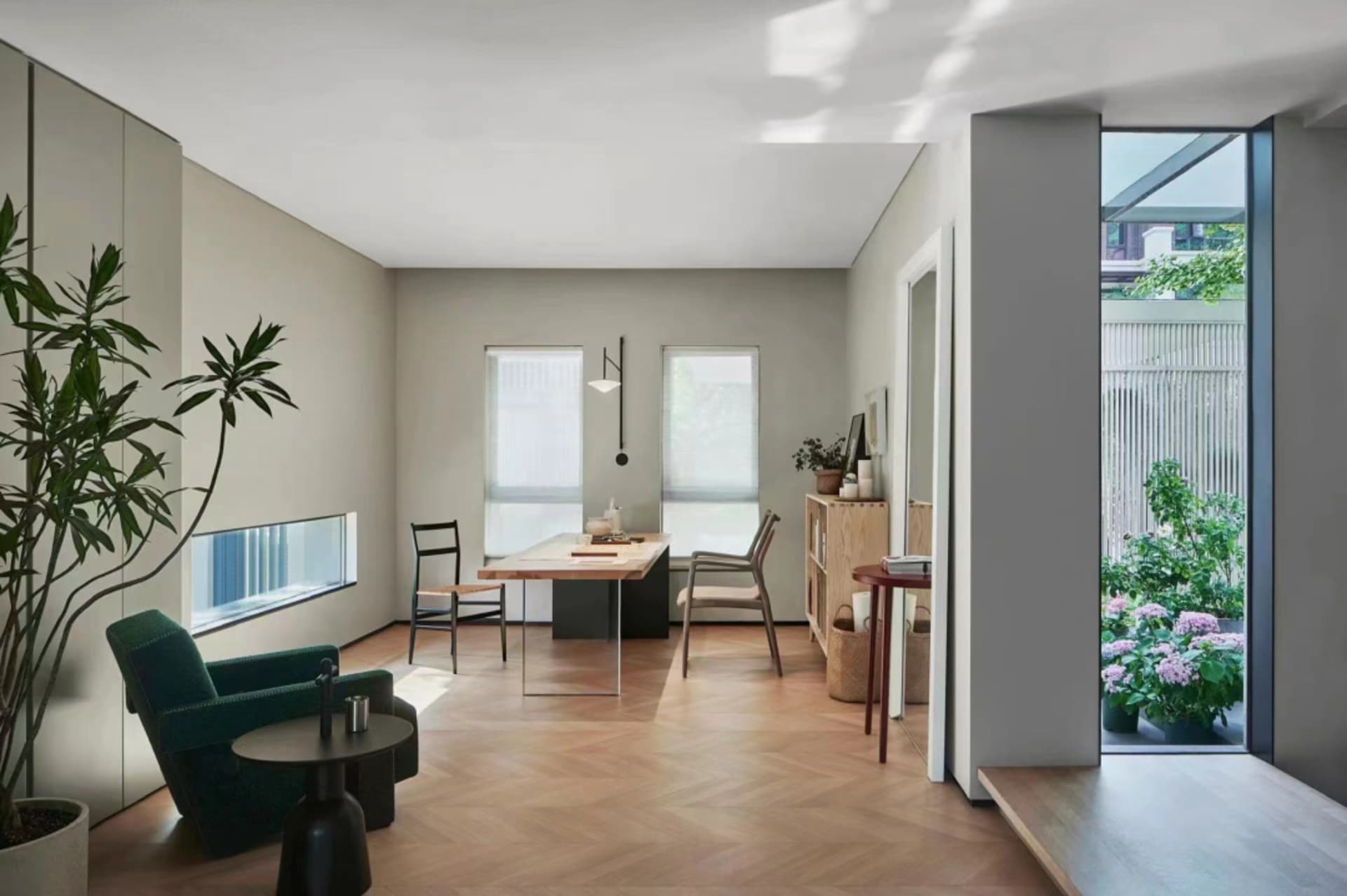 A minimalist residential space featuring wooden flooring, glass windows, and metal accents.