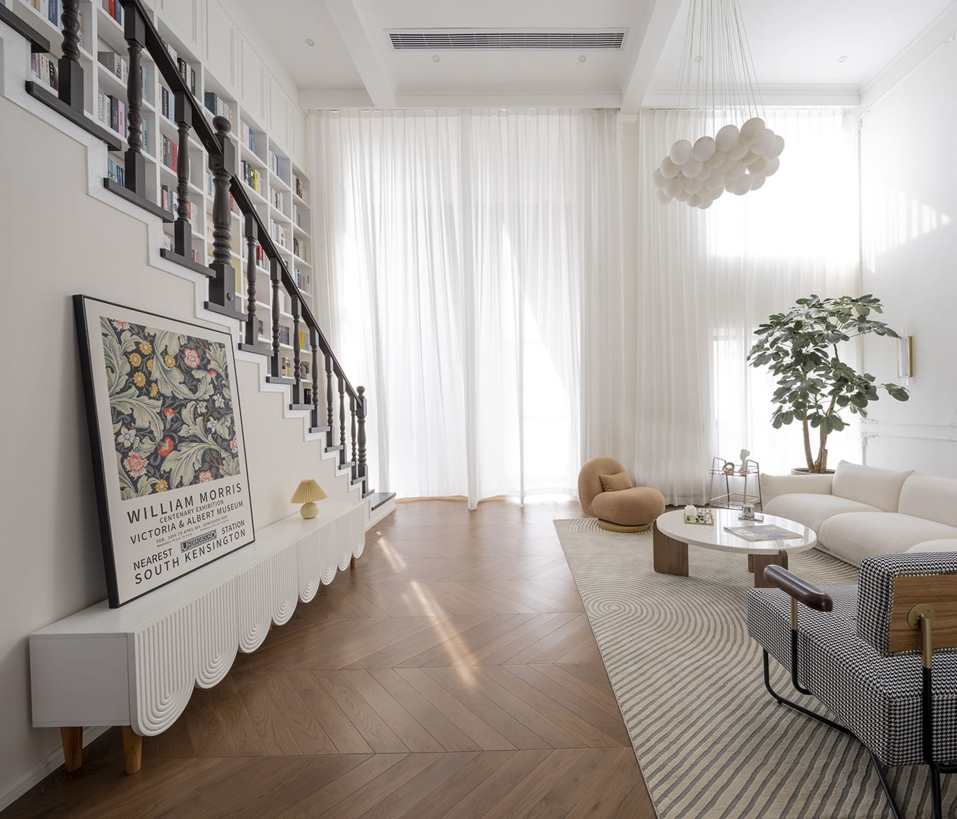 A modern living room featuring a herringbone-patterned floor and white curtains, creating a bright and spacious atmosphere.
