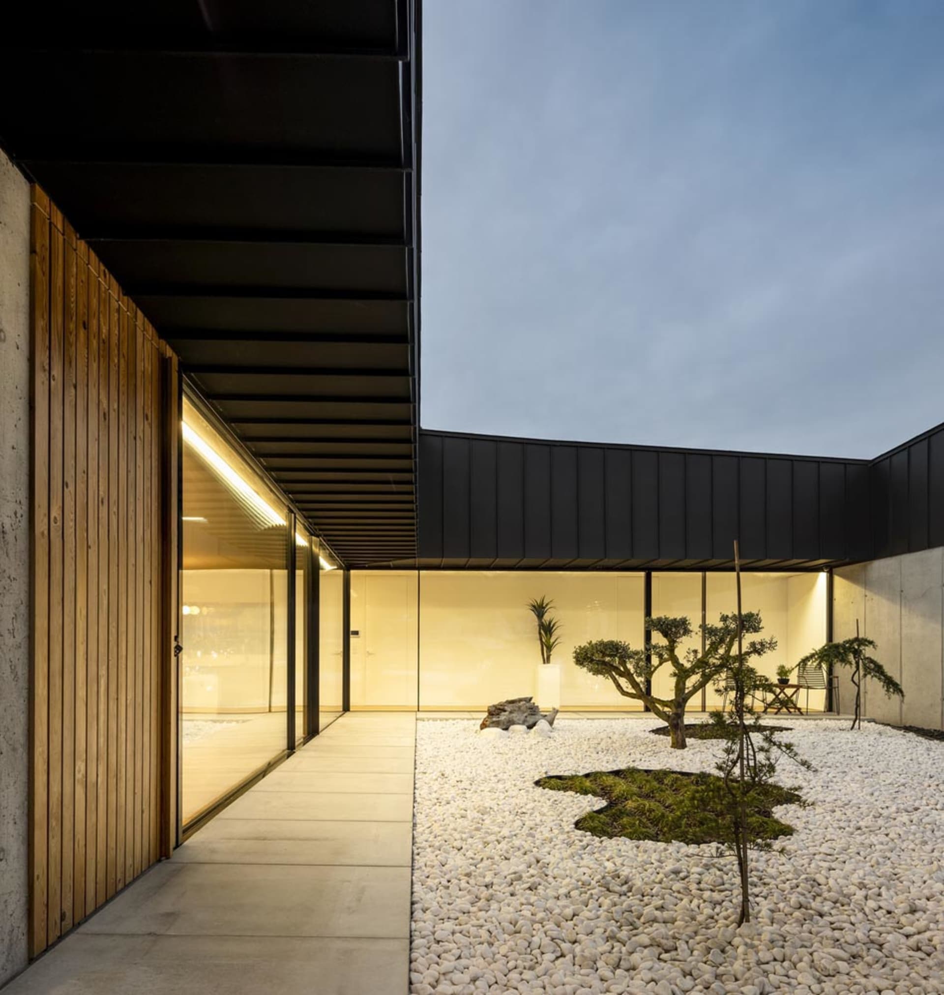 Modern residential entryway featuring concrete floor and glass walls.