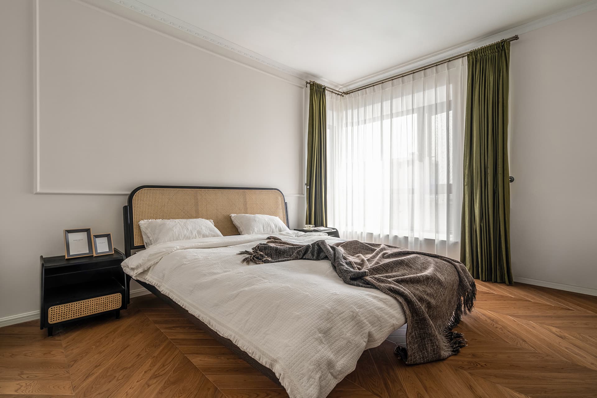 Modern minimalist bedroom featuring a woven headboard and wooden floor.