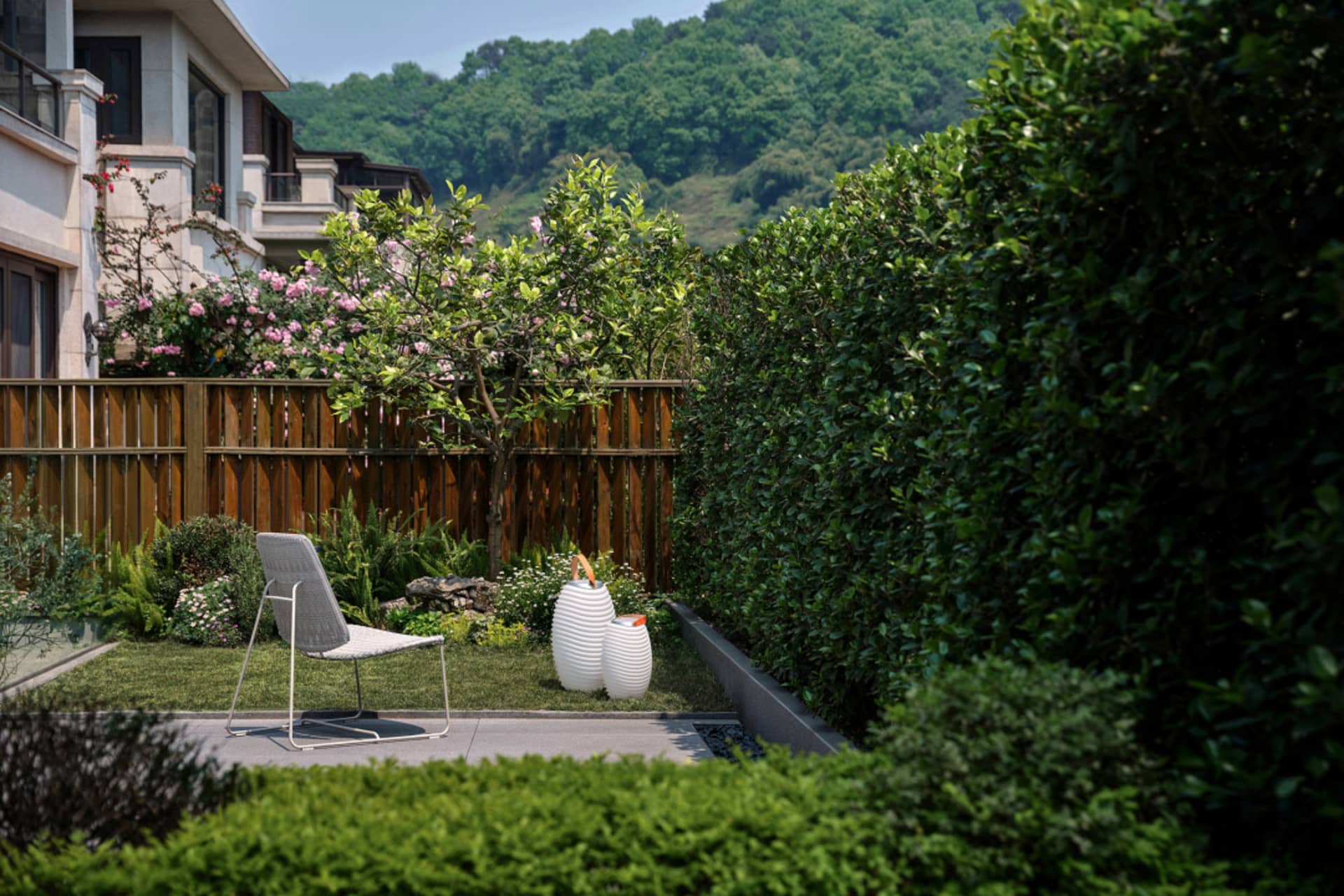 A modern outdoor space featuring a patio with a white chair, white vases, and lush greenery.