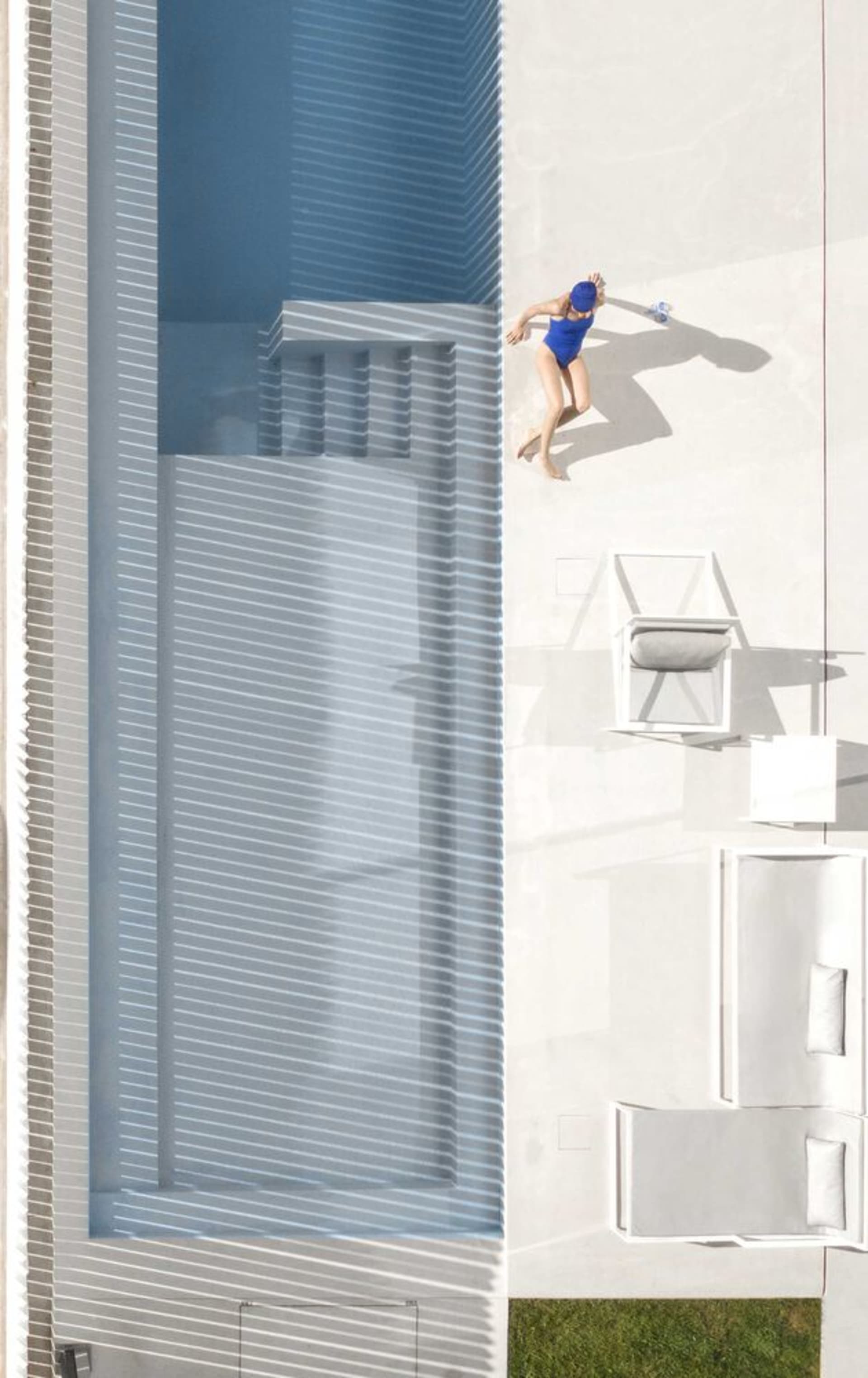 Aerial view of a modern poolside area with concrete structures and a person wearing a blue swimsuit and swim cap.