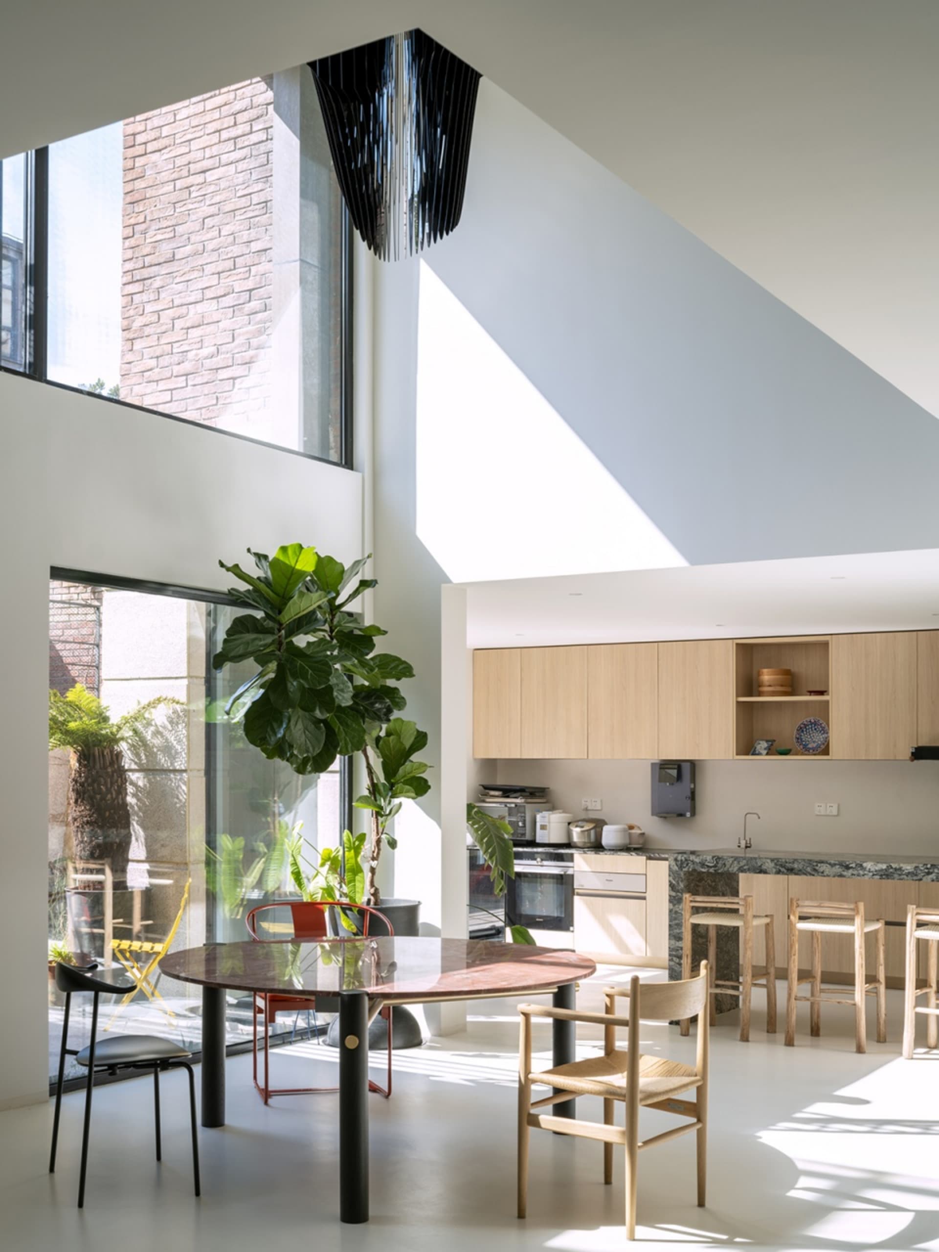 Modern kitchen and dining area featuring marble countertops and wooden furniture.