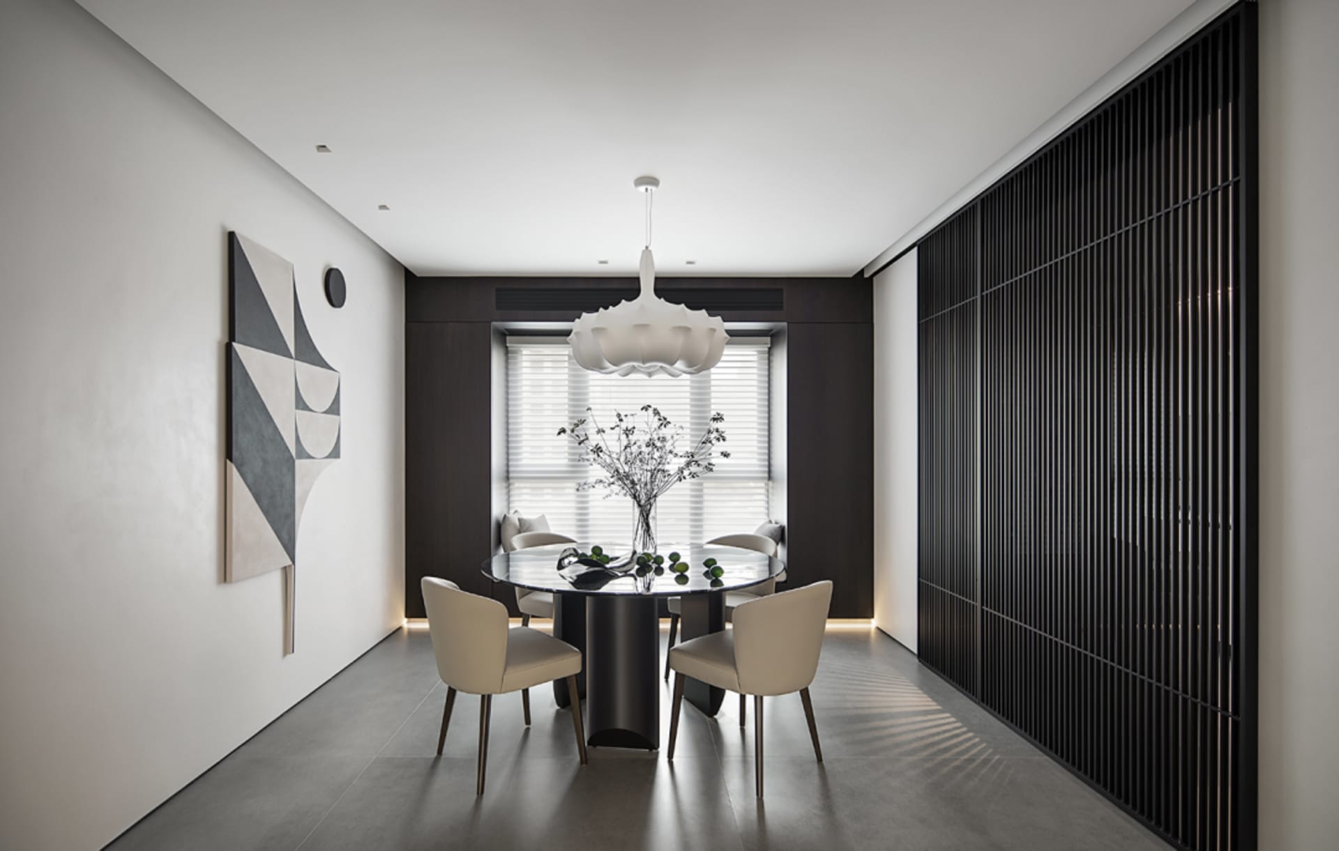 Modern dining room with a glass top dining table, wooden chairs, and a metal pendant light.