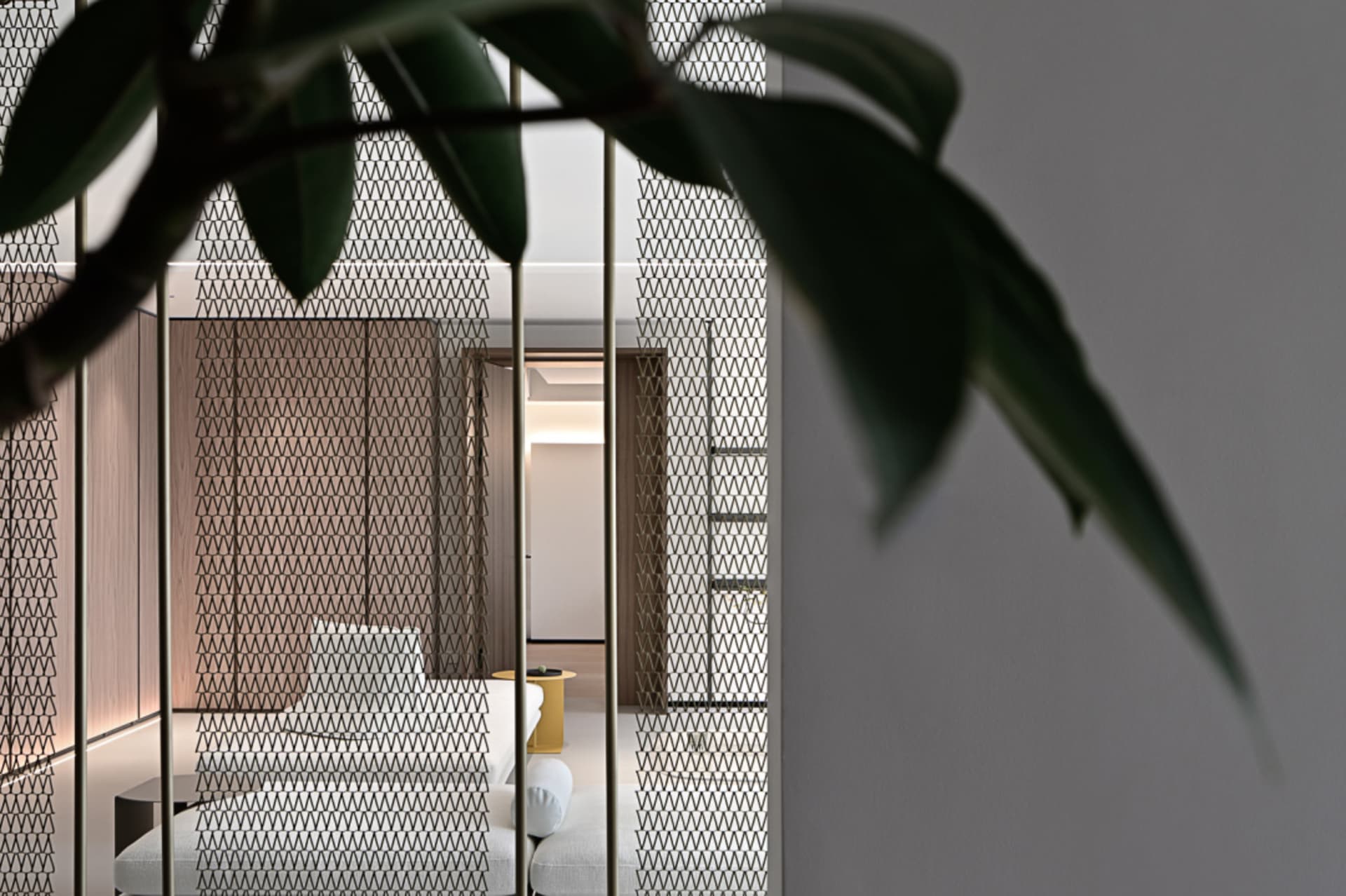 A modern living room with textured wallpaper, featuring a sleek sofa and contemporary decor.