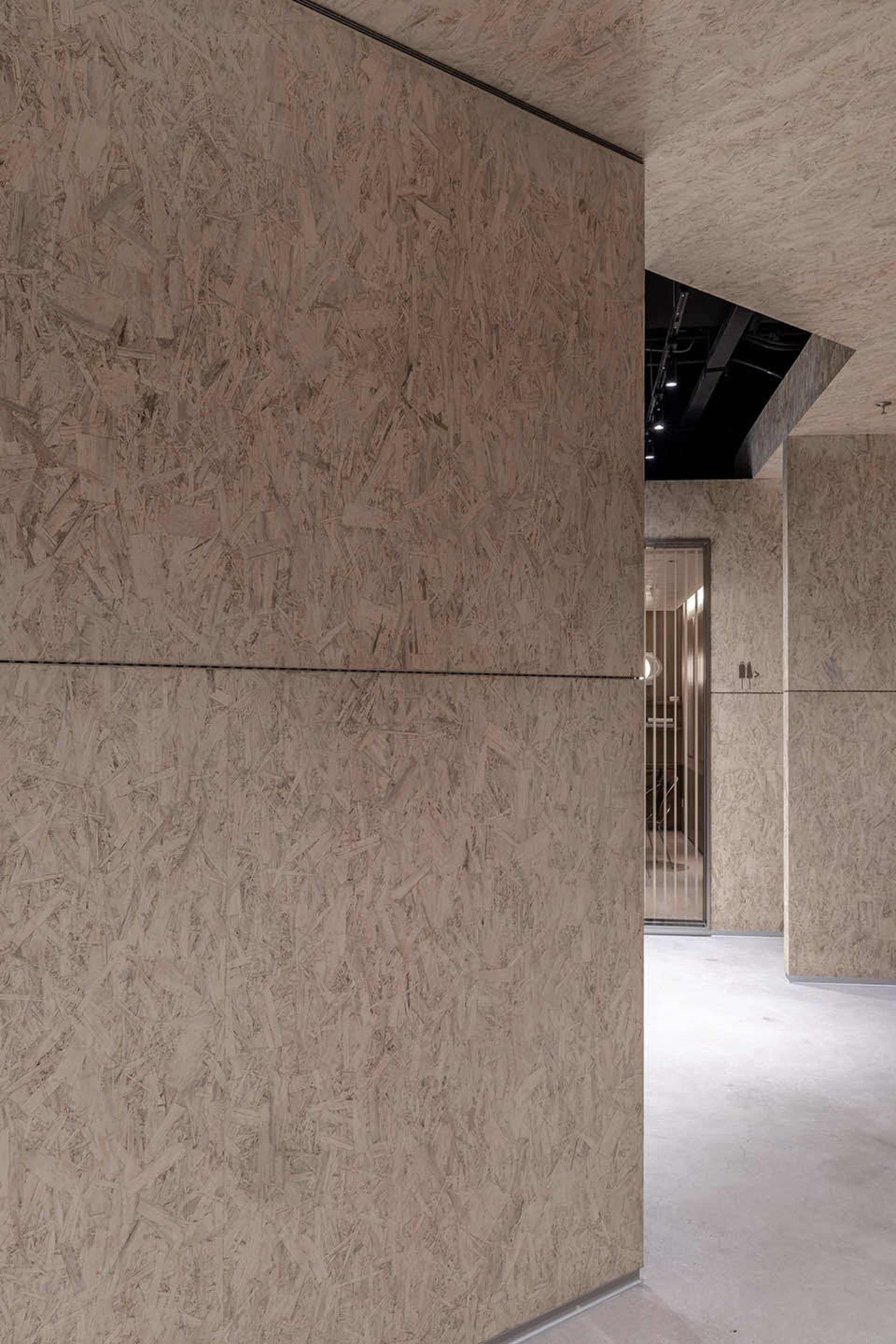 Modern office interior with OSB board paneling on the walls and ceiling.