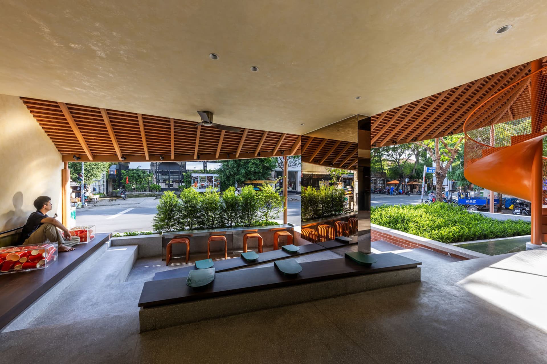 A wooden bench and chairs create a cozy seating area in a room with a natural atmosphere, surrounded by trees outside