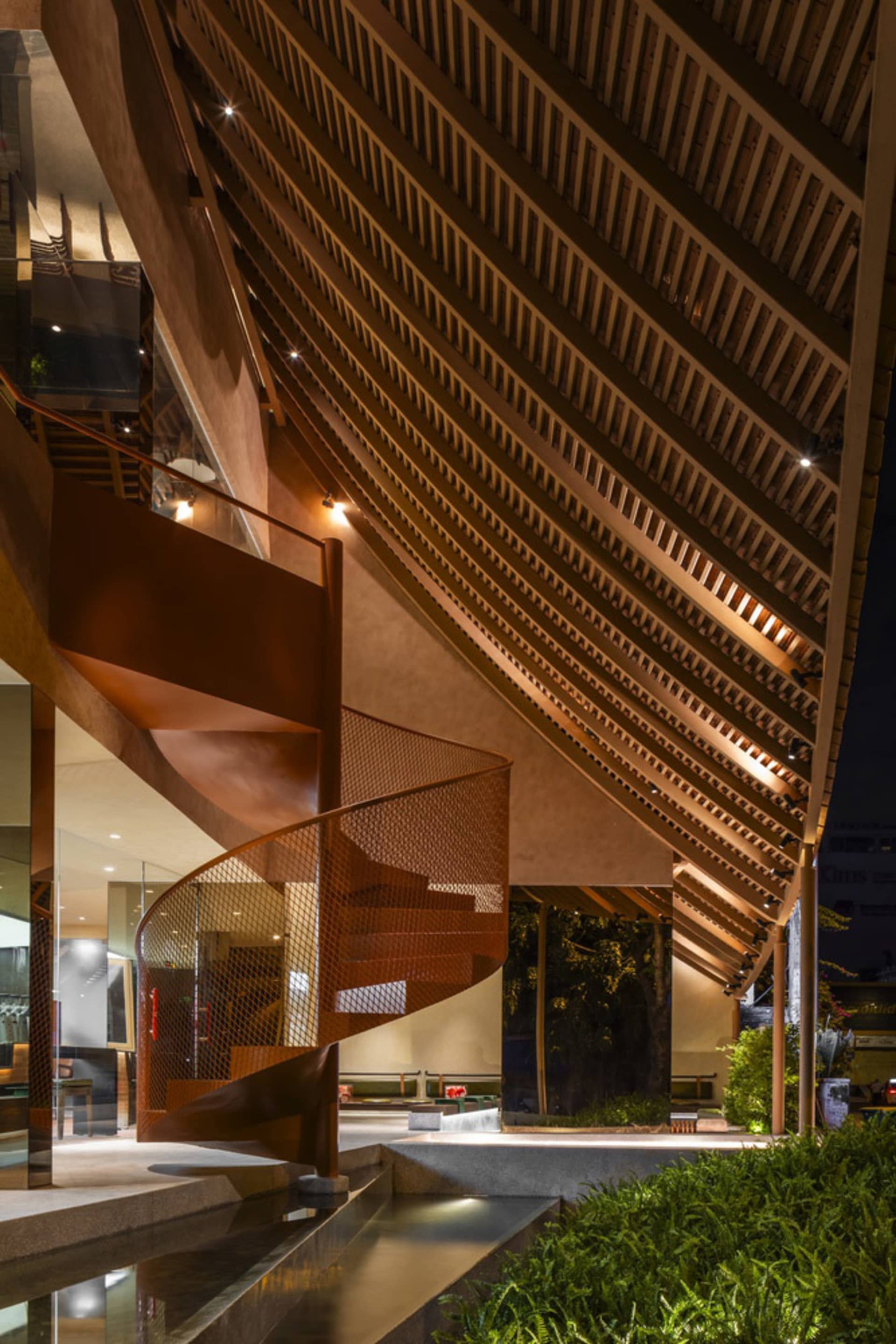 A wooden building with a spiral staircase leading to a balcony, featuring a brown wooden exterior and intricate design details