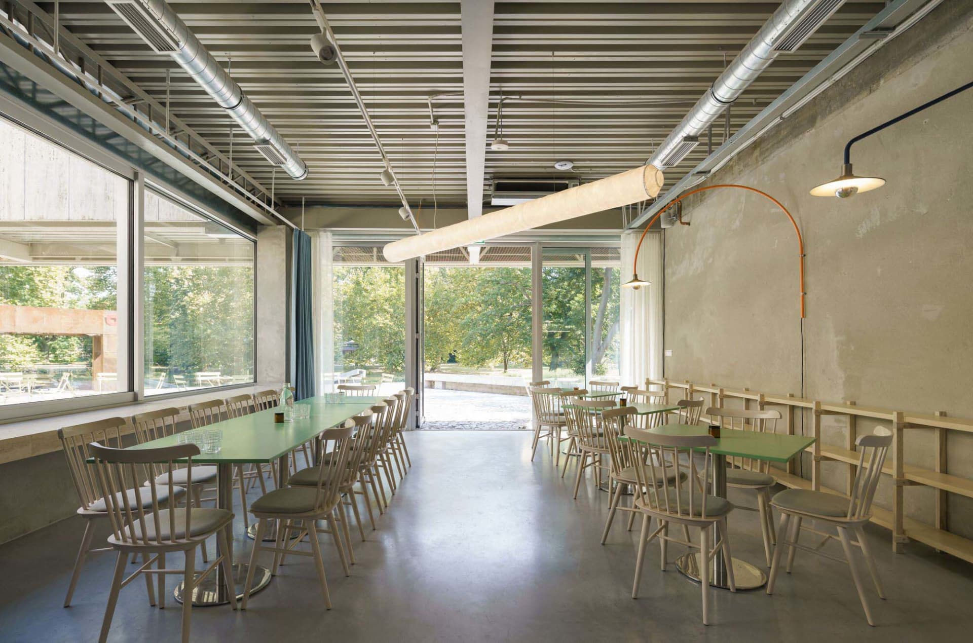 A bright and inviting restaurant interior with multiple dining tables and chairs, modern design, and ample seating options
