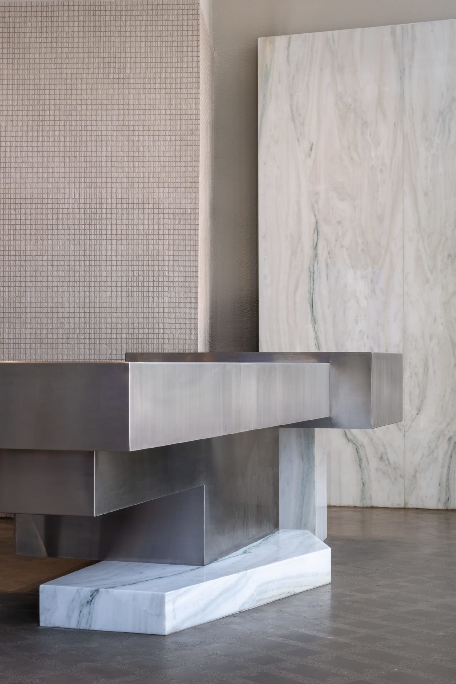 A modern interior space with a large stainless steel countertop, clean lines, and a minimalist aesthetic