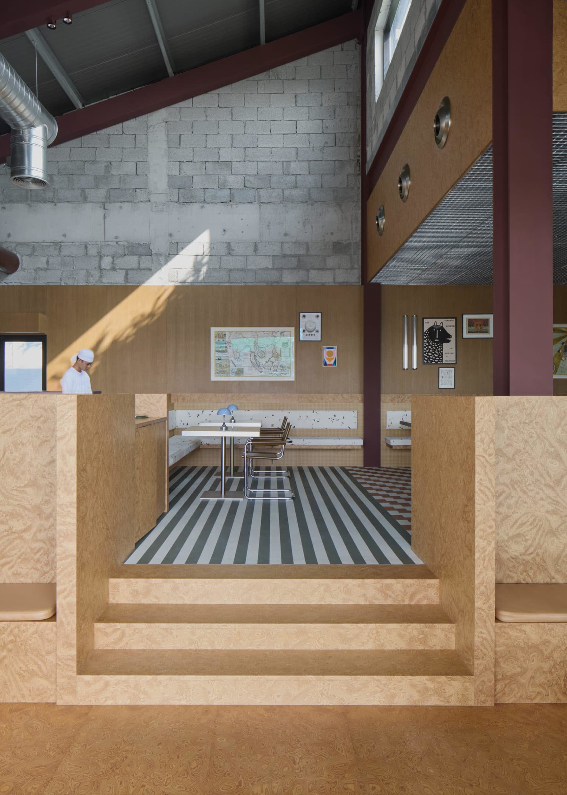 Dining area with wooden walls, two tables, and chairs, featuring a warm and inviting atmosphere