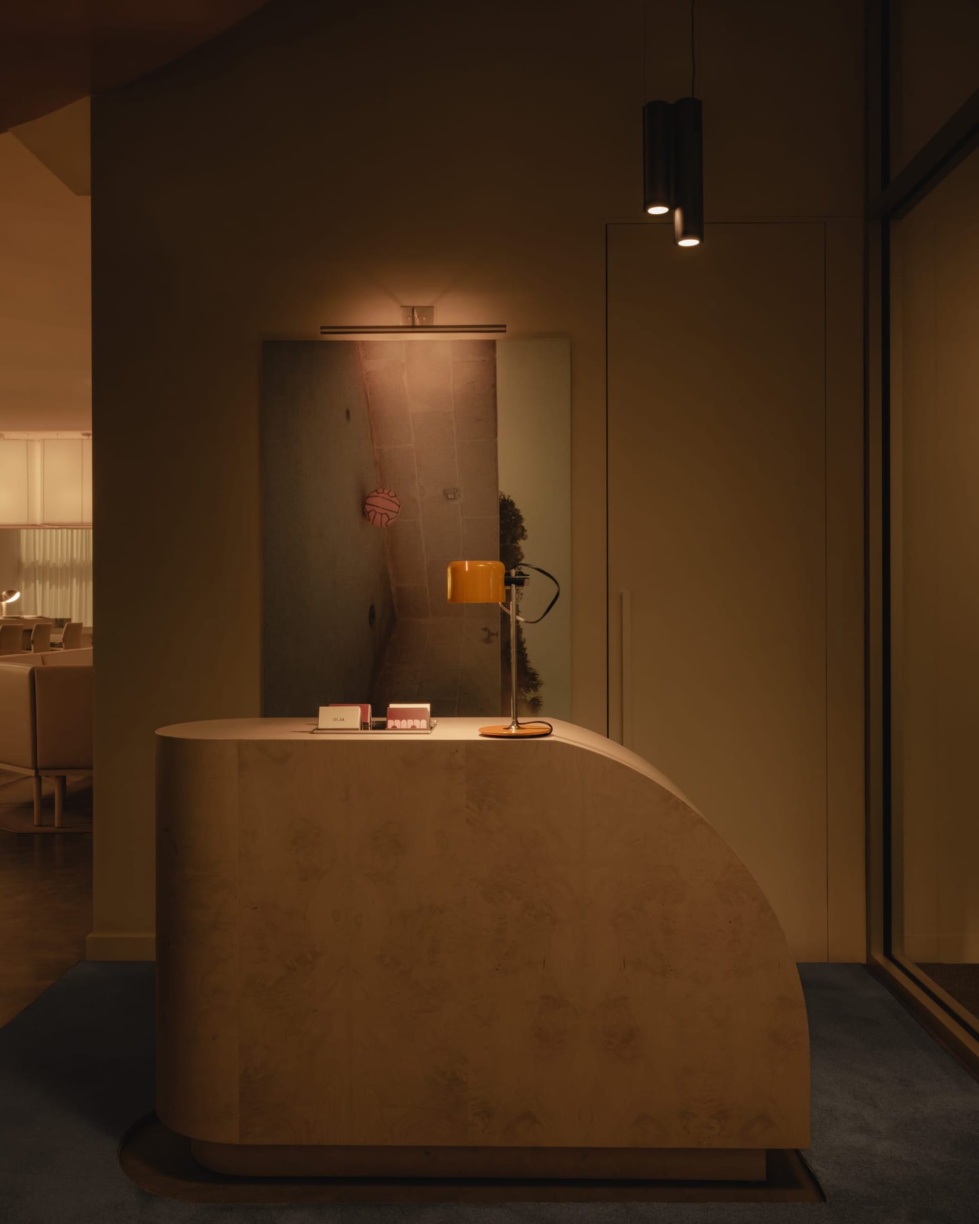 A warm and inviting room with a countertop, mirror, chairs, and a lamp, creating a cozy seating area