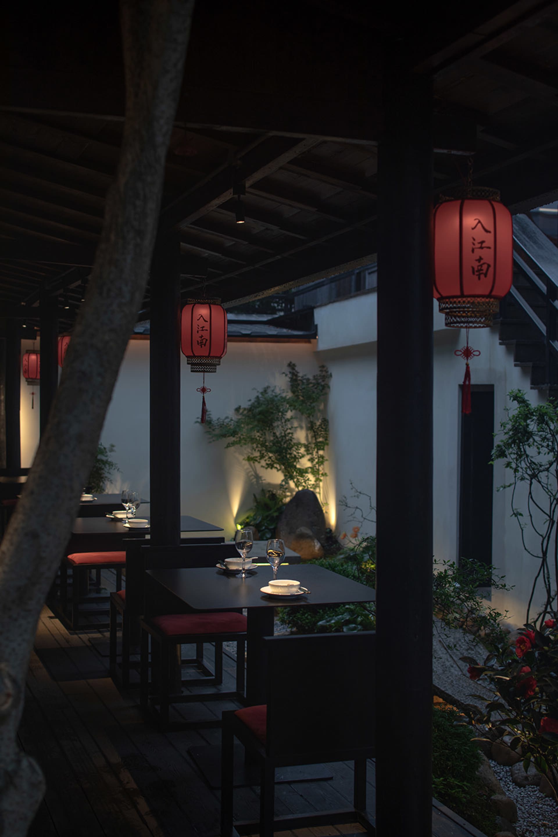 帶頂棚的露台用餐區，配有黑色桌椅、酒杯與悠閒氛圍