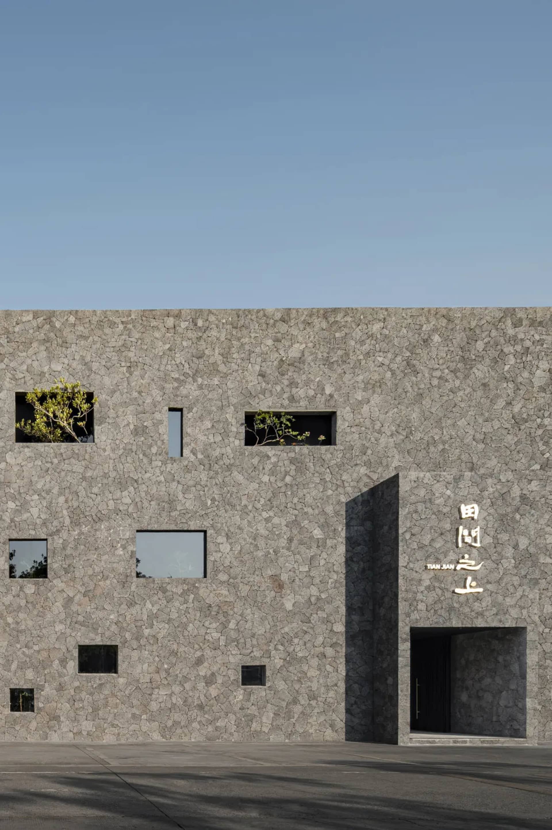 Modern hotel or office building with a stone exterior, large windows, and a sophisticated design