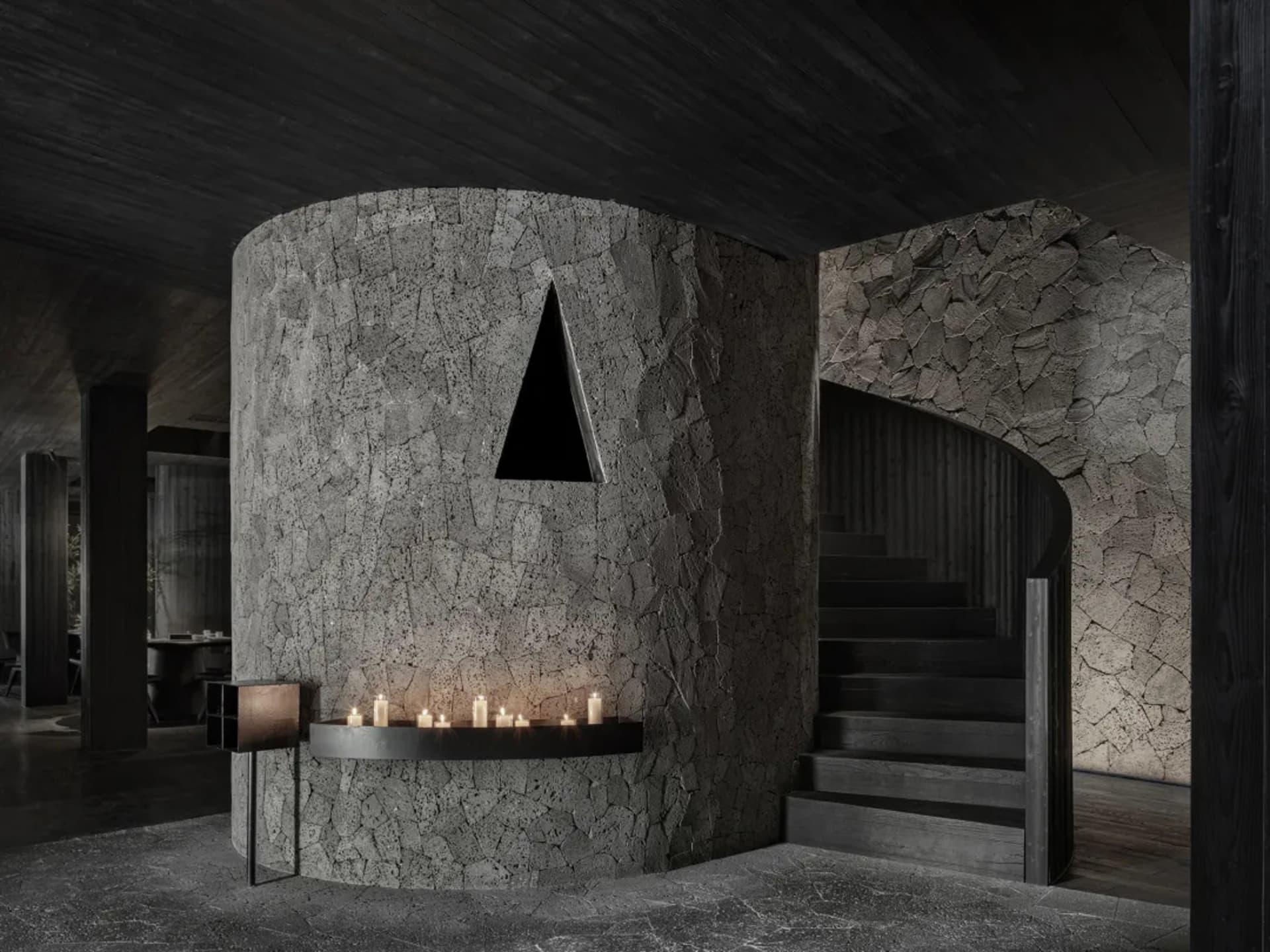 A modern staircase with two sets of steps leading to a stone wall, with a minimalist design and wooden stairs