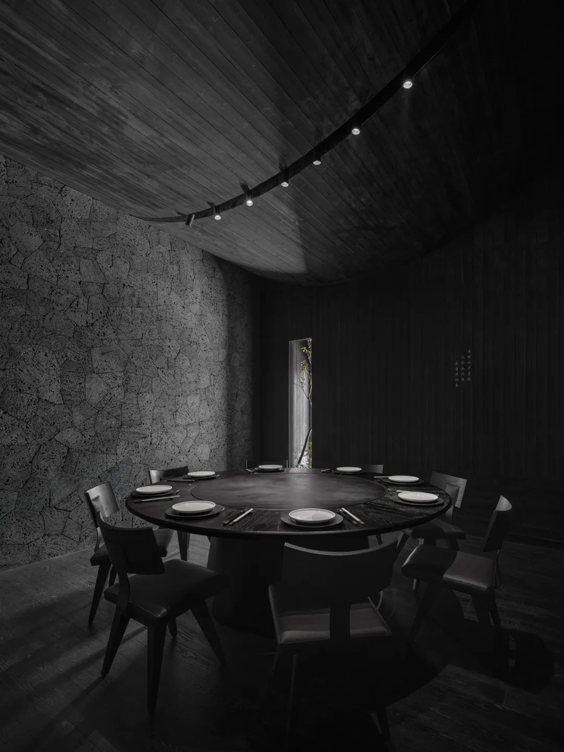 Dimly lit dining area with a round table and chairs, creating a mysterious ambiance