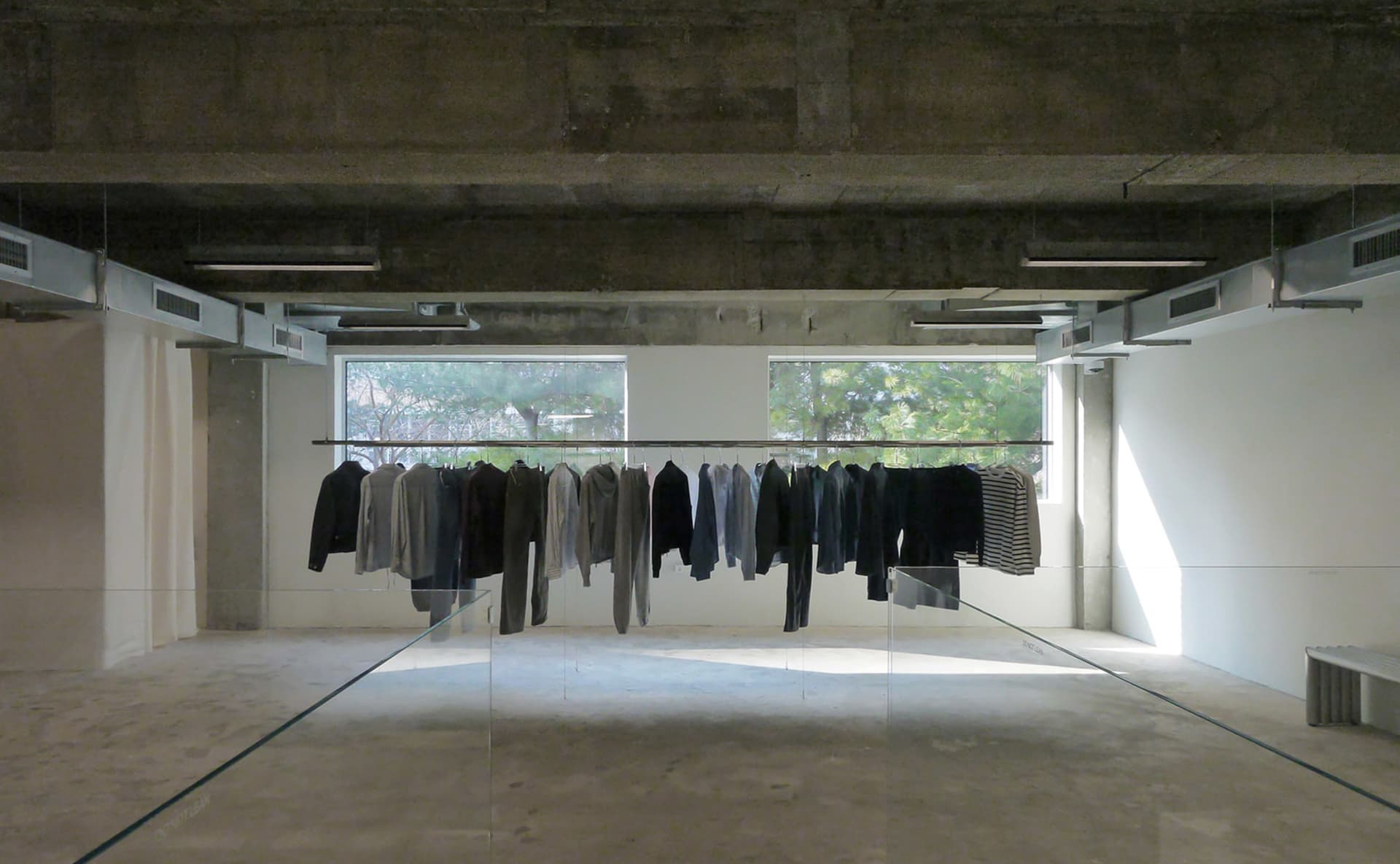 Empty room with a glass display case showcasing various jackets of different sizes and styles, creating a clean and organized atmosphere
