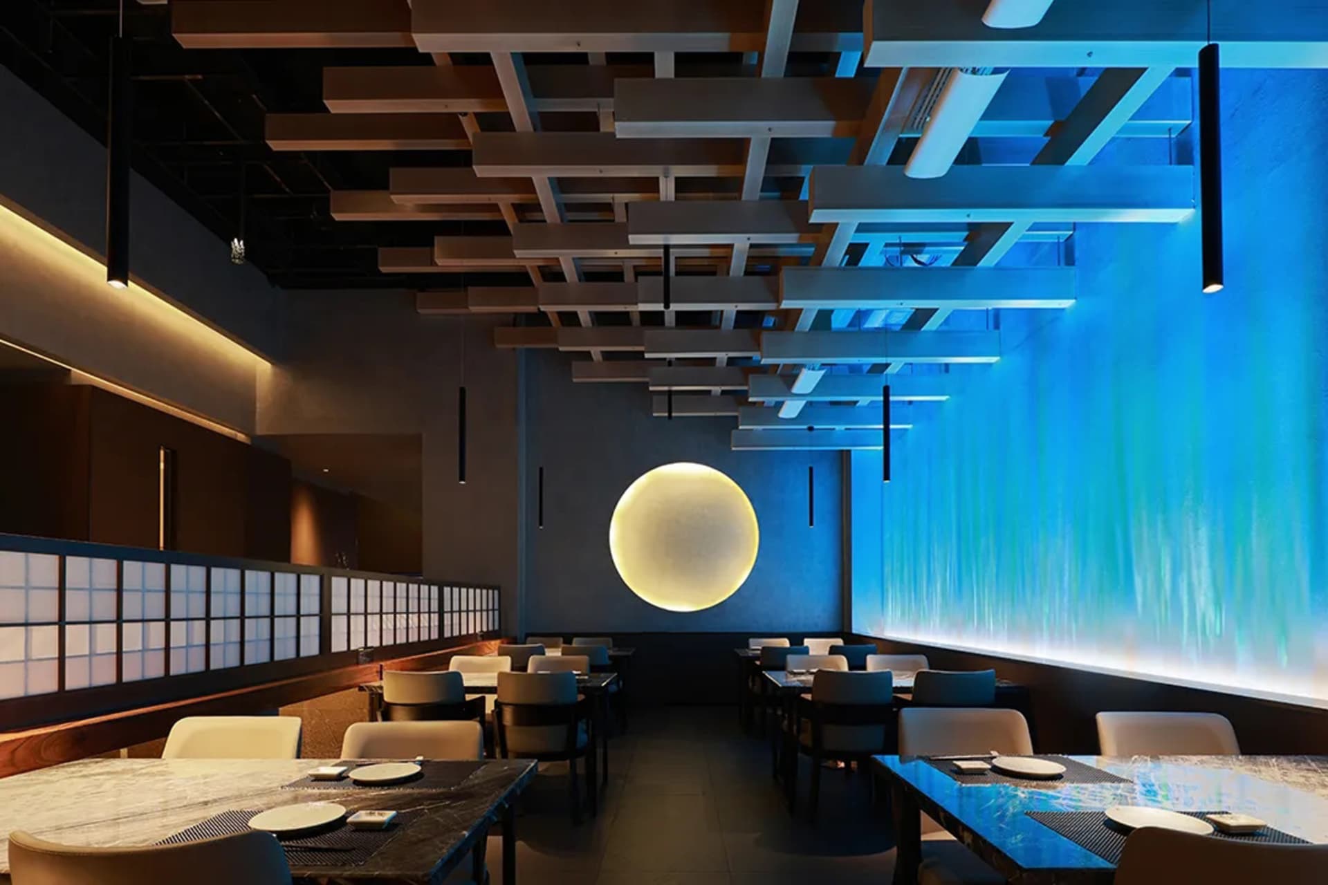 空蕩蕩的餐廳內部，配有大型餐桌與藍白牆面，營造現代而溫馨的氛圍