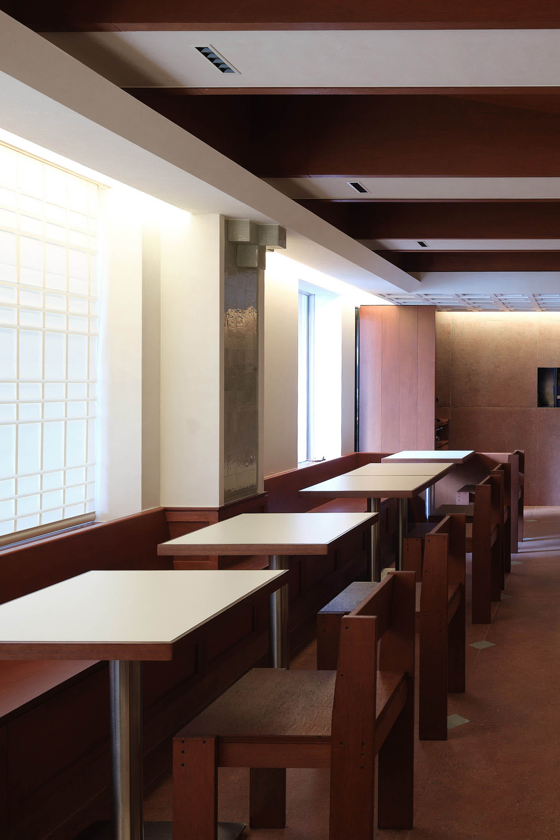 Empty classroom with wooden tables, benches, and chairs, creating a calm and quiet atmosphere