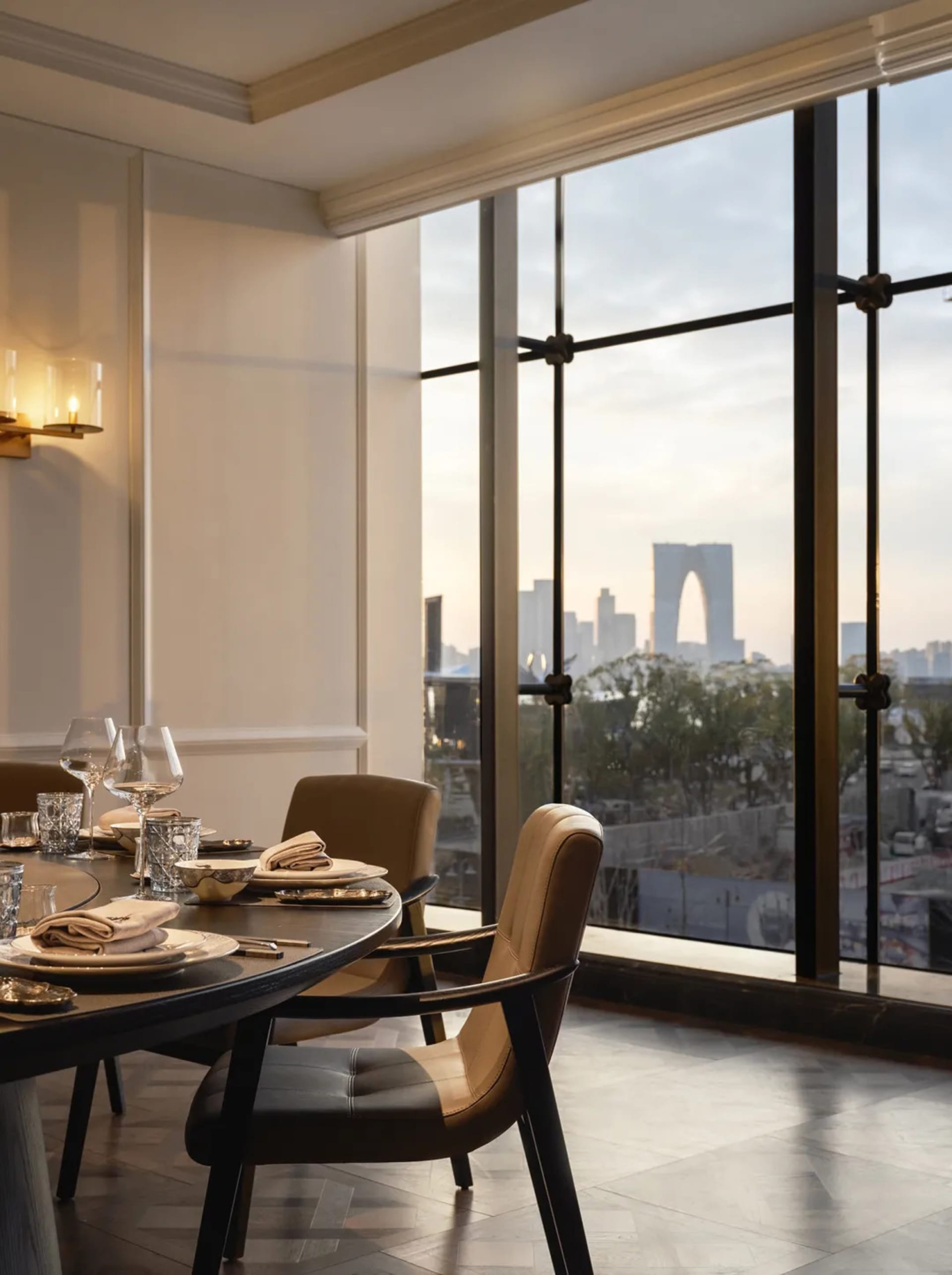 Dining area with glass window, city skyline view, fine dining elements, and comfortable seating for guests