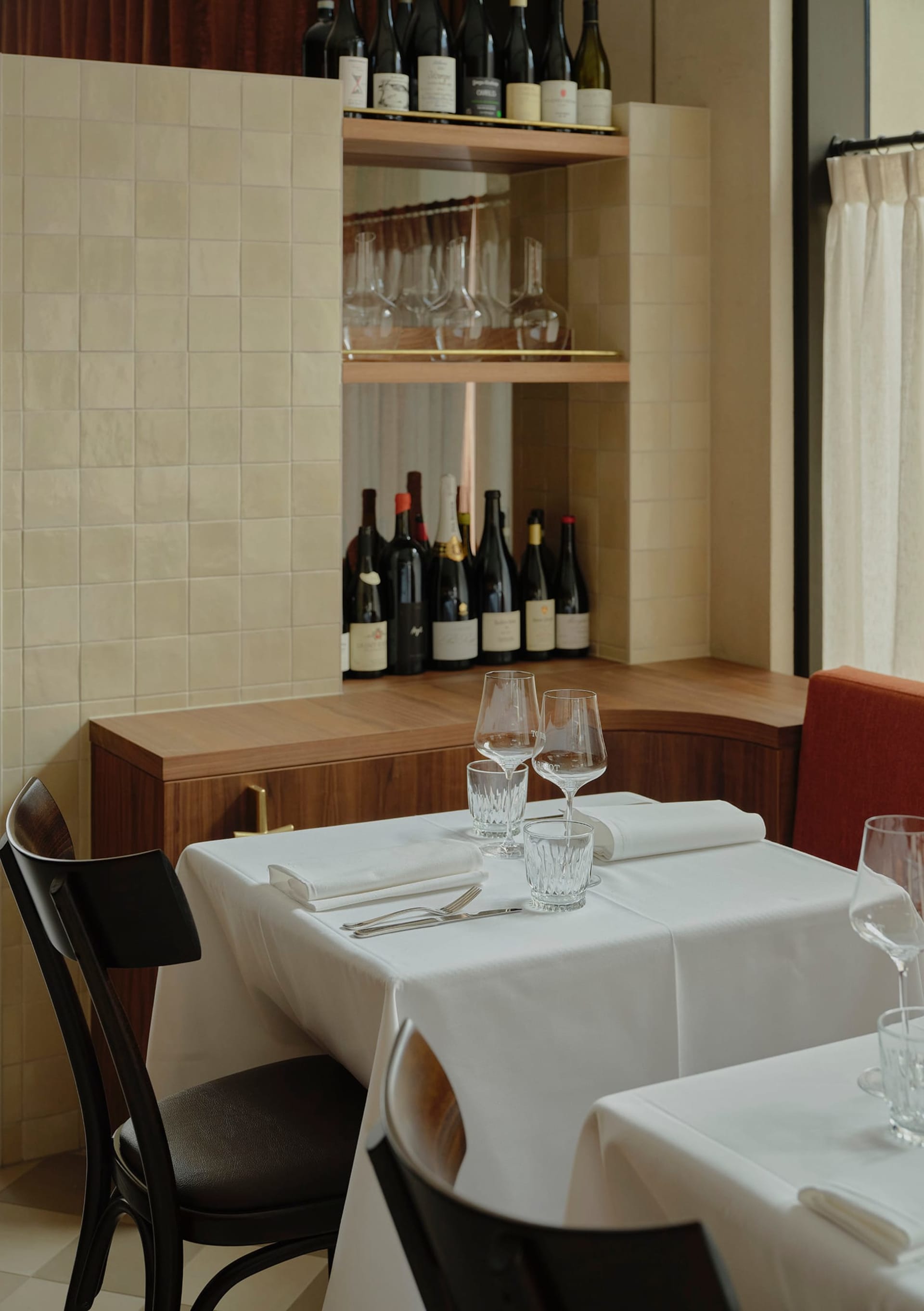 A formal dining area with a table set for dinner, wine glasses, and multiple chairs, creating a sophisticated atmosphere for a special occasion or romantic evening